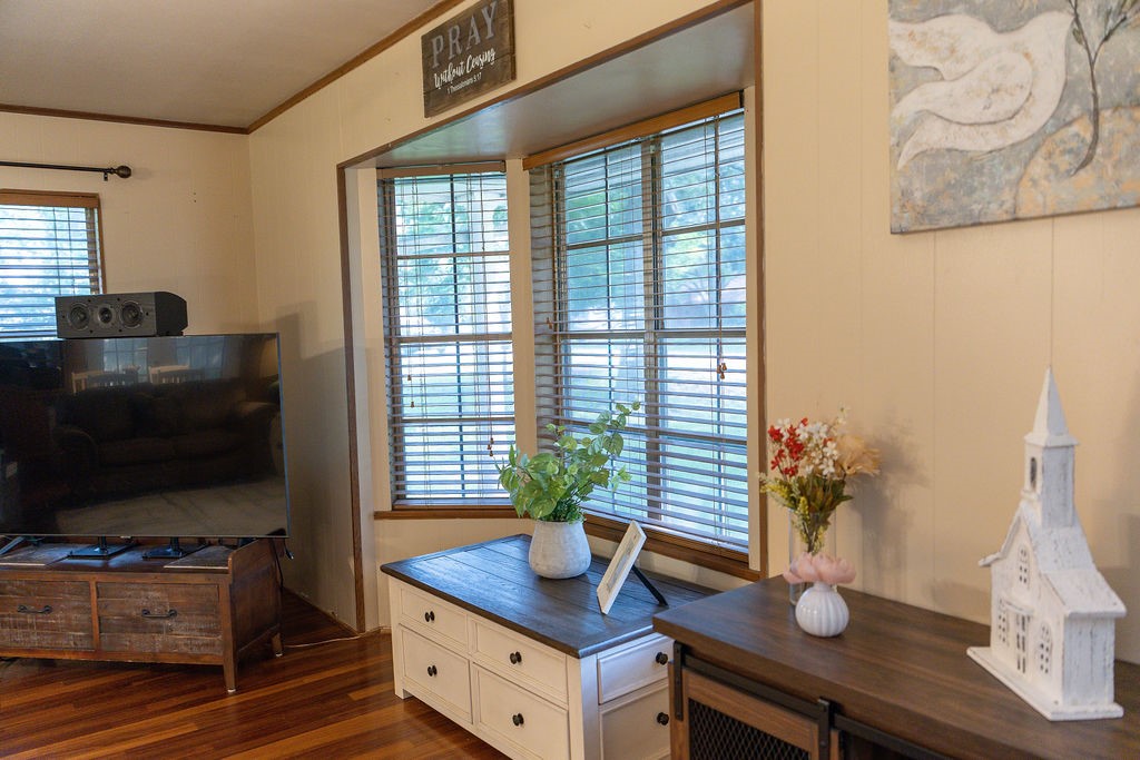 A classic bay window overlooks the stunning mature trees in the front yard, filling the room with natural light while providing a peaceful view and adding timeless charm to the space