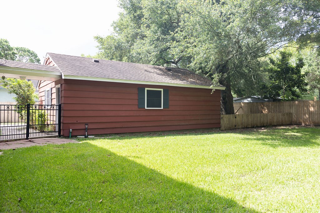 Here's another view of the oversized garage and the expansive, fully fenced backyard. With abundant outdoor space, there's plenty of room for kids and pets to play, gardening, entertaining, or simply enjoying the privacy and peaceful surroundings.