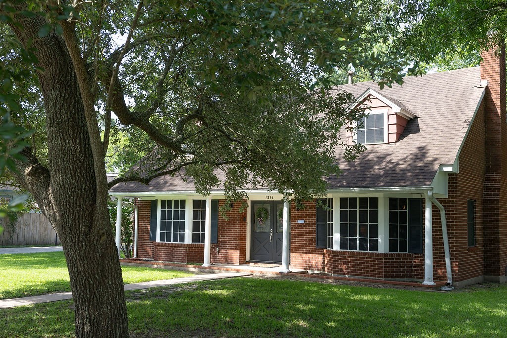 Charming brick home with a gabled roof, large front windows, and a welcoming front porch. Surrounded by lush greenery and mature trees, it offers a serene and inviting atmosphere. Charming brick home with a gabled roof, large front windows, and a welcoming front porch. Surrounded by lush greenery and mature trees, it offers a serene and inviting atmosphere.