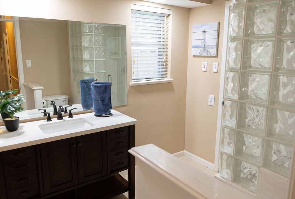 The downstairs bathroom has been beautifully updated with a stylish vanity and a spacious walk-in shower, offering both modern design and everyday convenience for guests and family alike.