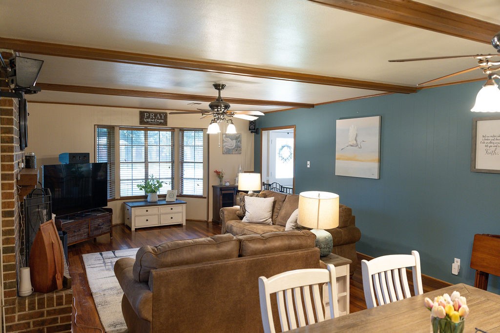This spacious family room and dining room combination showcases rich accent walls and beautifully stained faux wood beams, adding warmth, character, and a custom designer touch. It's the perfect blend of timeless elegance and comfortable living, creating an inviting space for entertaining or relaxing with family.