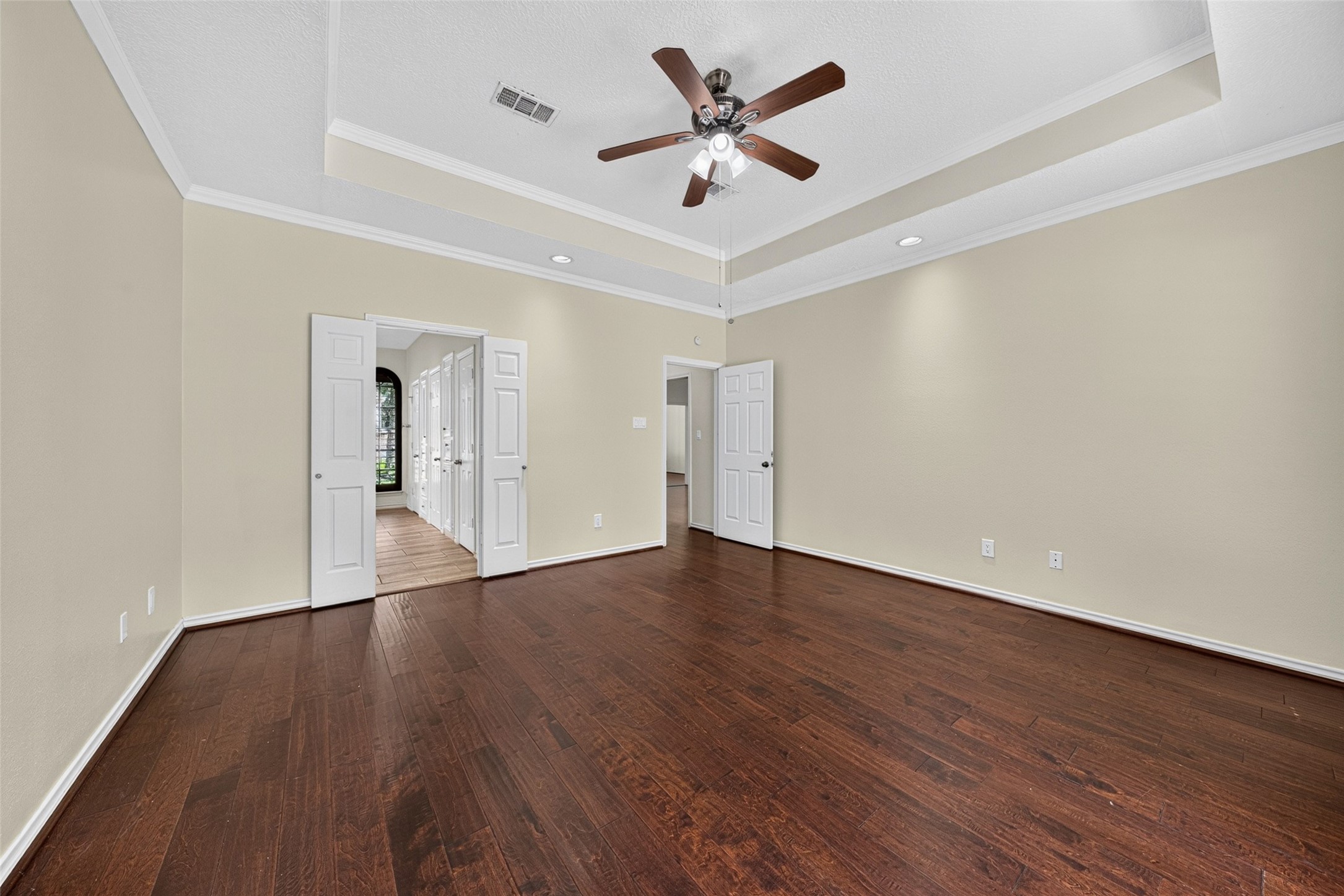 Double doors lead to the primary bathroom enhancing the room's elegance and accessibility.