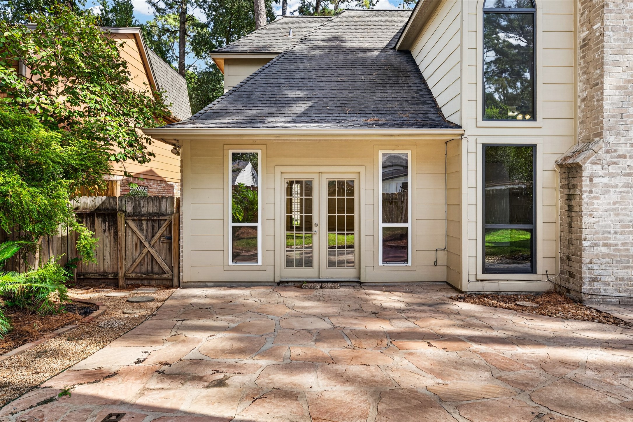 The primary suite is just beyond these french doors extedning the the primary suite to the back patio.