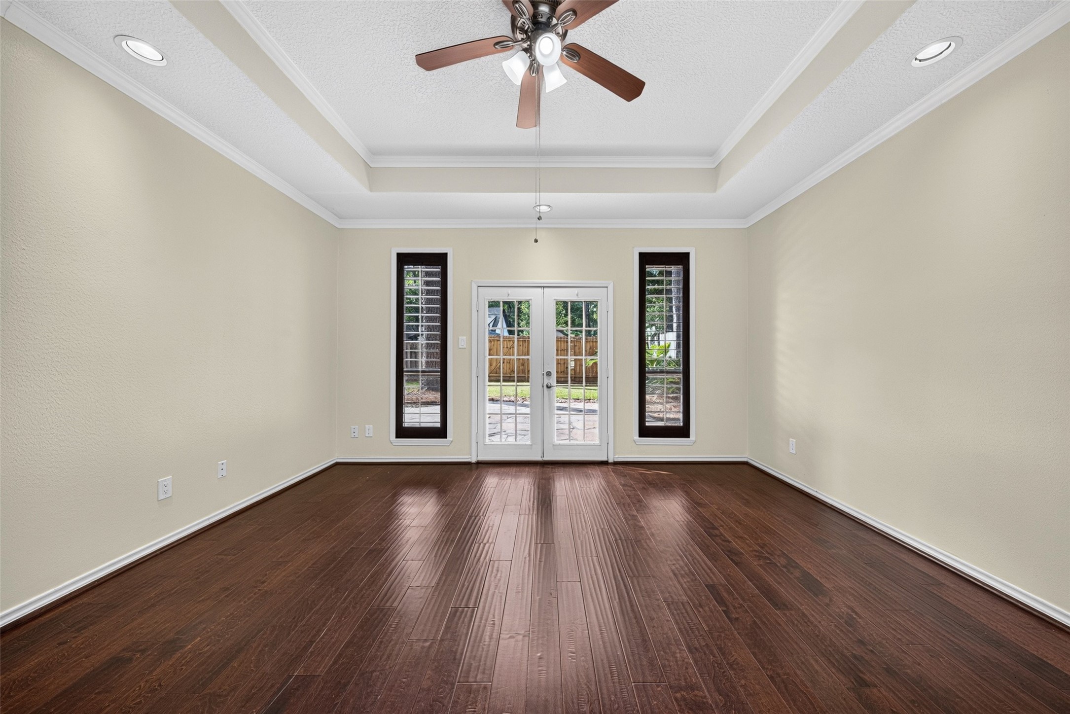 The primary suite is located off the back of the home with french doors leading to the back patio.