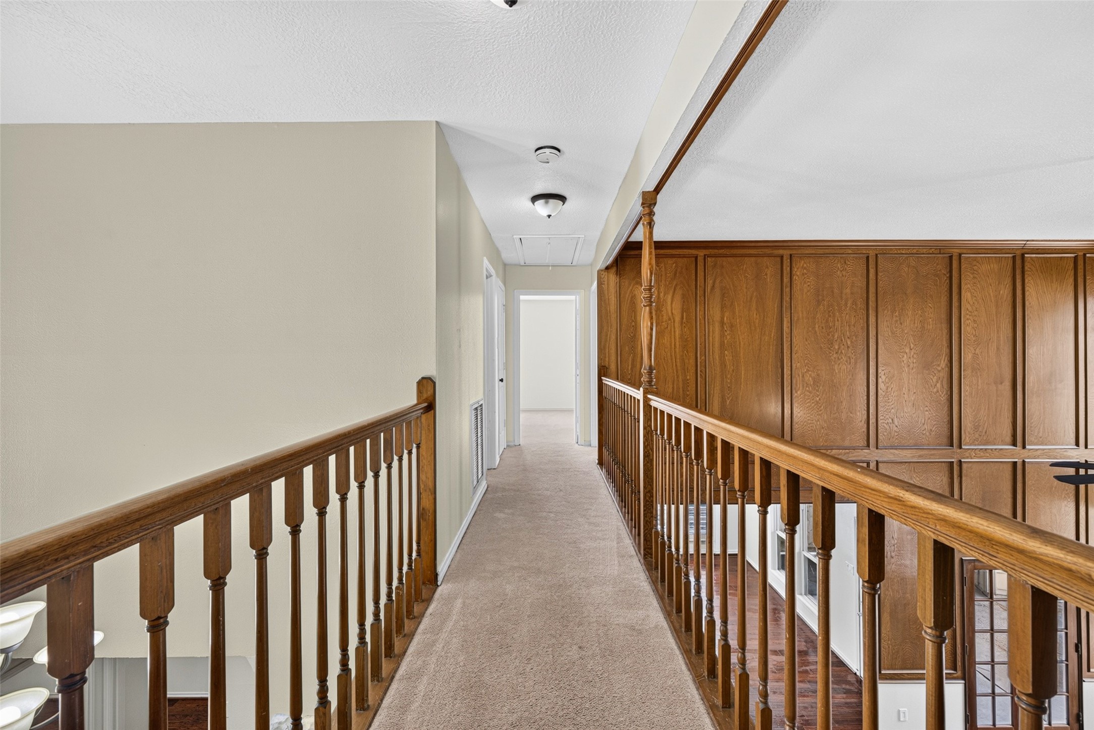 The upper-level cat walk balcony connects the upstairs bedrooms while offering a view of the beautiful living room.