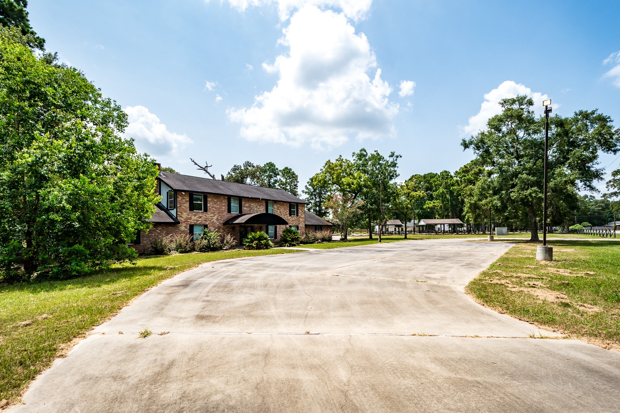 Spacious brick home with a long driveway, surrounded by lush greenery and mature trees, offering a serene and inviting atmosphere. Spacious brick home with a long driveway, surrounded by lush greenery and mature trees, offering a serene and inviting atmosphere.