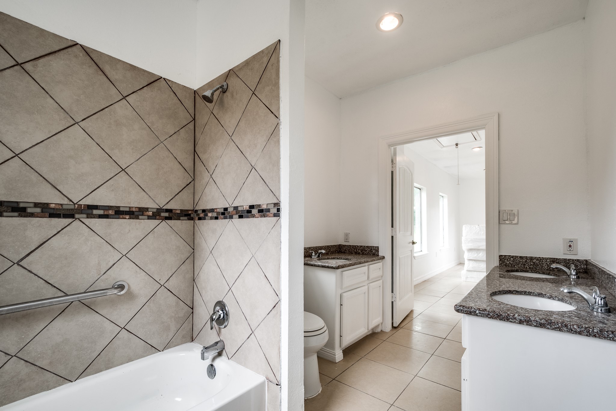 Bathroom in building #2 with 3 sinks and tub/shower combination.