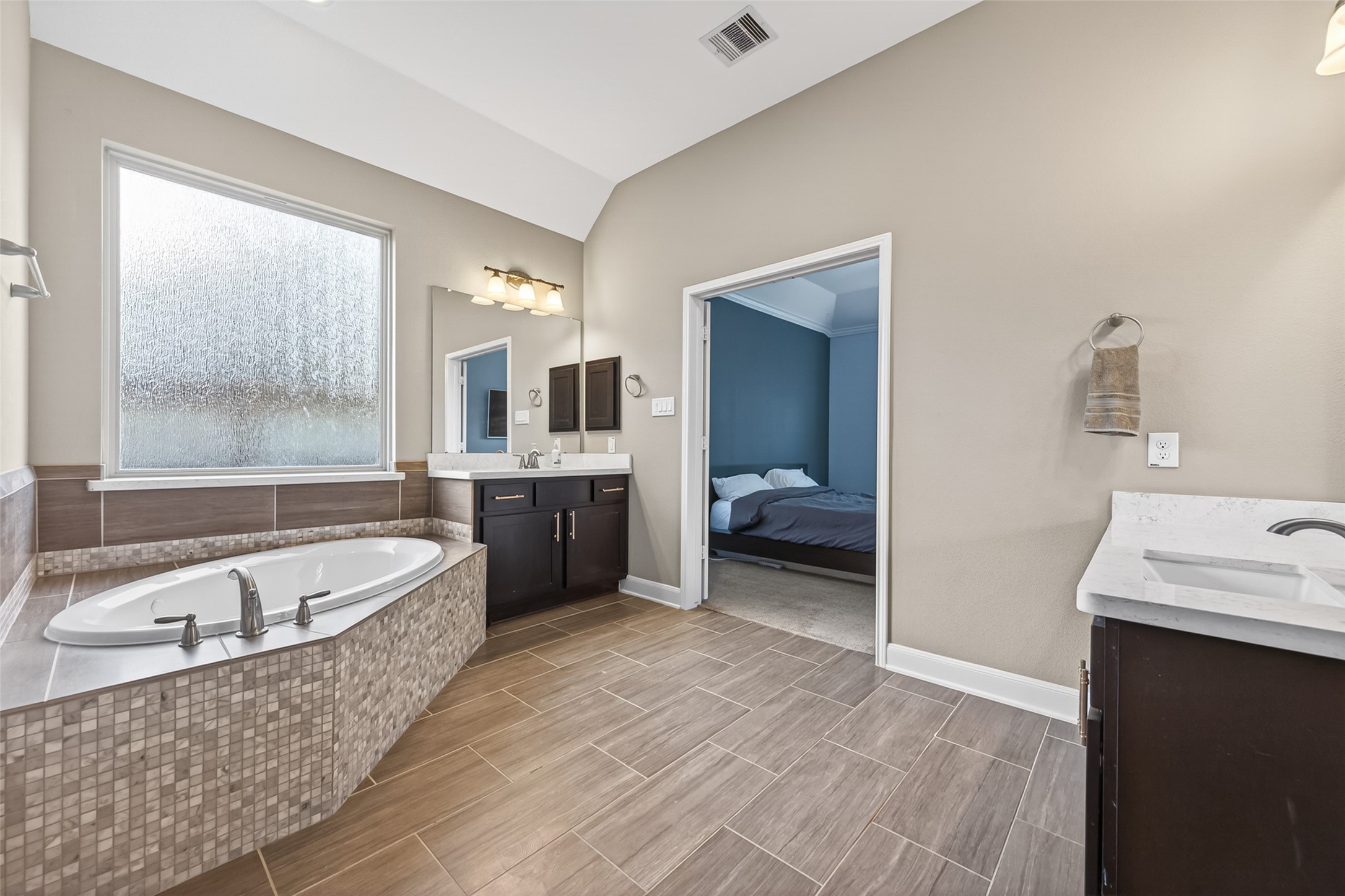 Oversized primary bathroom with 2 sinks, soaking tub, and walk-in shower.