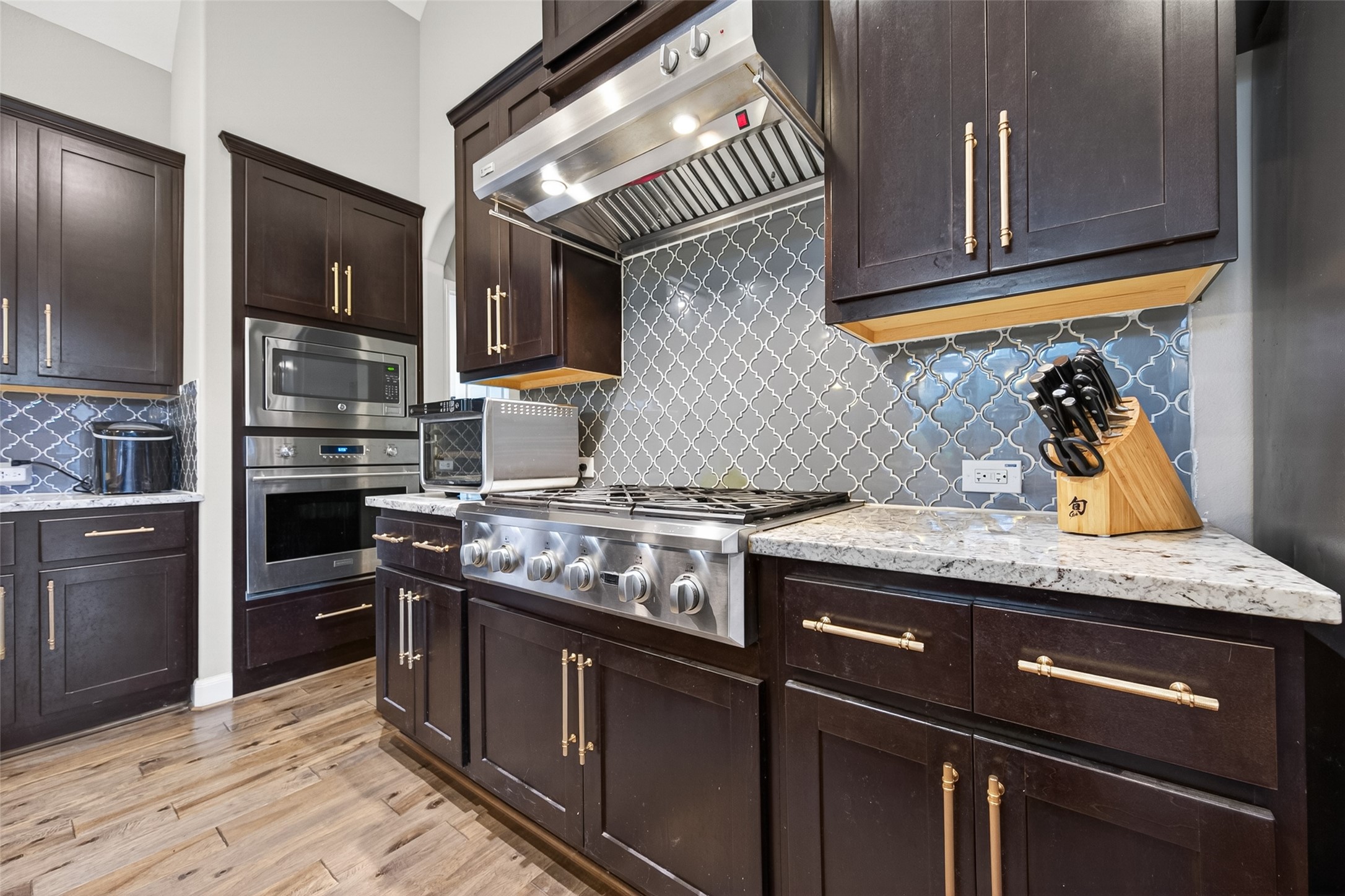 Top of the line stainless steel Monogram appliances with radiant food warmer and several burners.