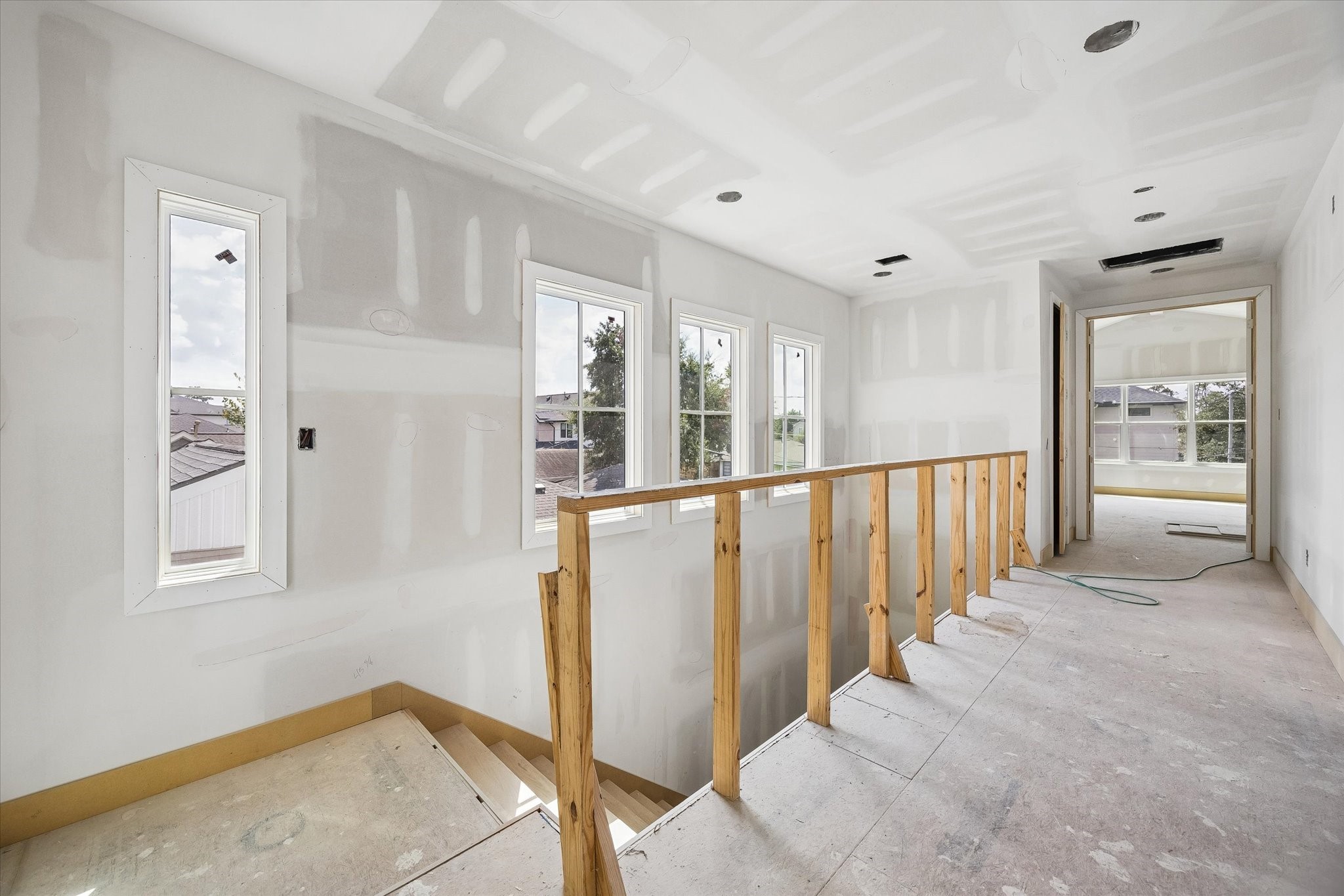 Natural light pours into the upstairs landing through a series of tall windows, creating a bright transition between the secondary bedrooms, game room and primary suite. **Current Construction as of 9/11/26