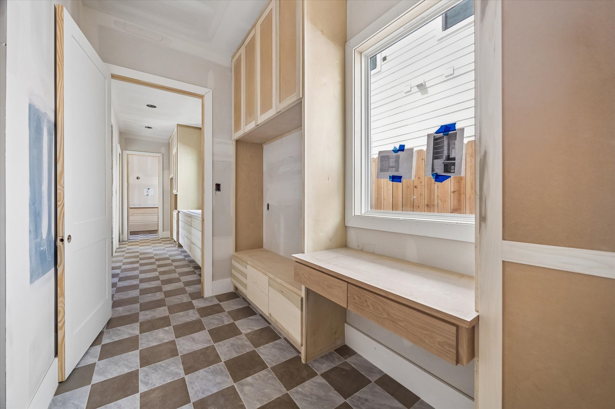 A thoughtfully designed mud room keeps everyday routines organized with custom built ins, generous cabinetry, and a dedicated drop zone. Checkerboard flooring adds character while a large window brings natural light into the space. **Current Construction as of 9/11/26
