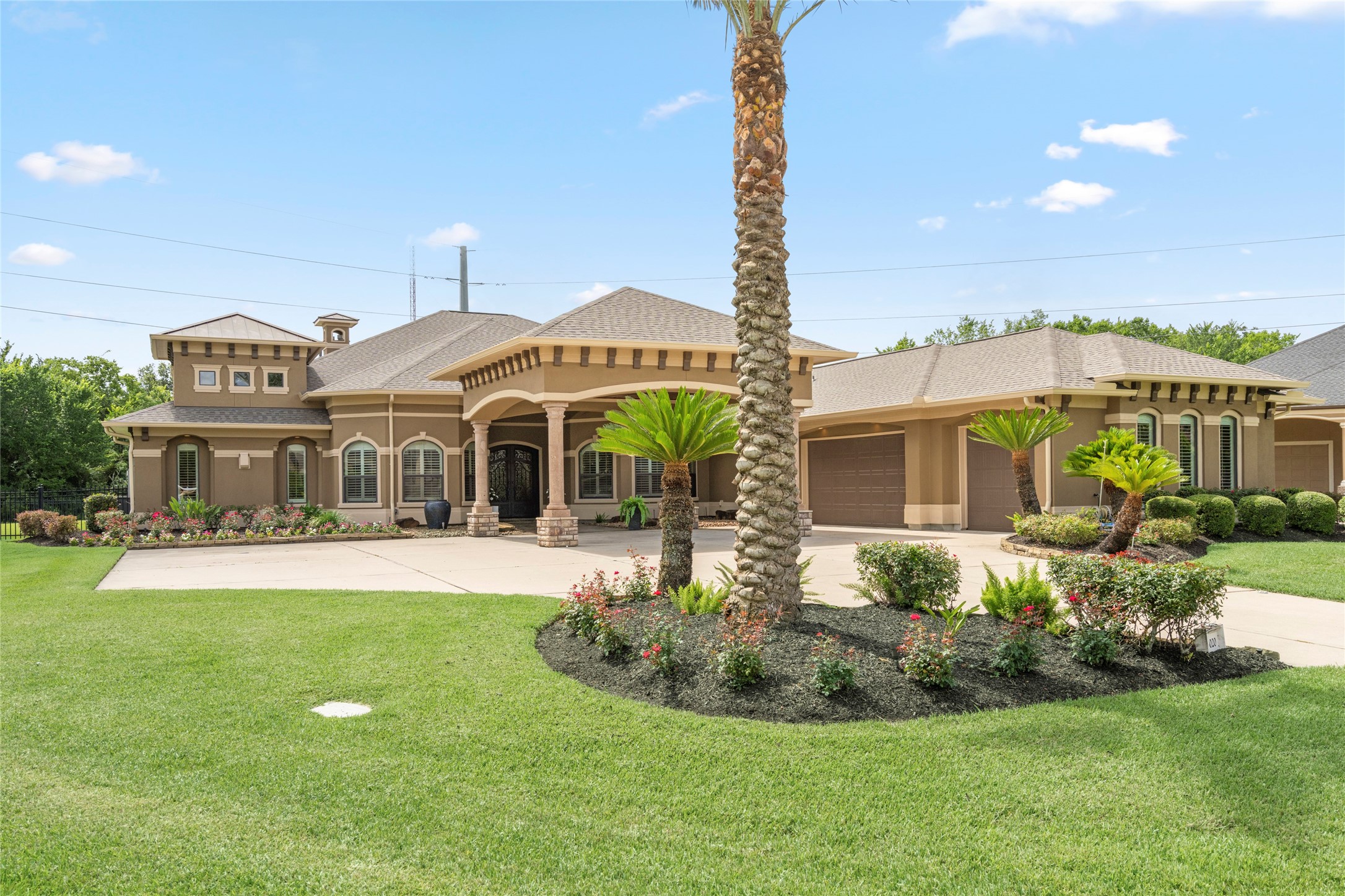 Striking front elevation featuring a covered entry, elegant architectural details, and extra parking for guests and multiple vehicles.