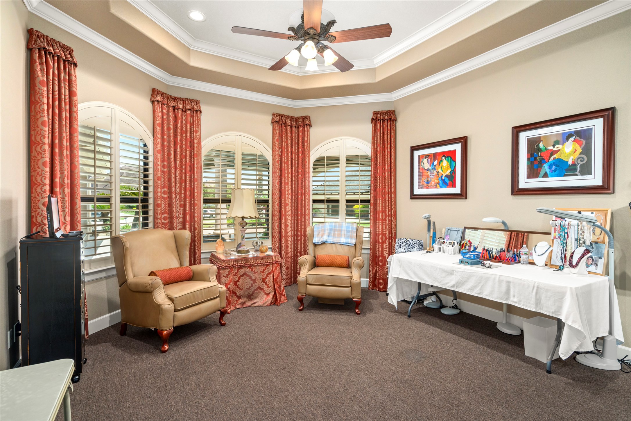 Secondary bedroom used as a craft room with a private en-suite bathroom. Complete with a wall of windows overlooking the front of the home with custom wood shutters.
