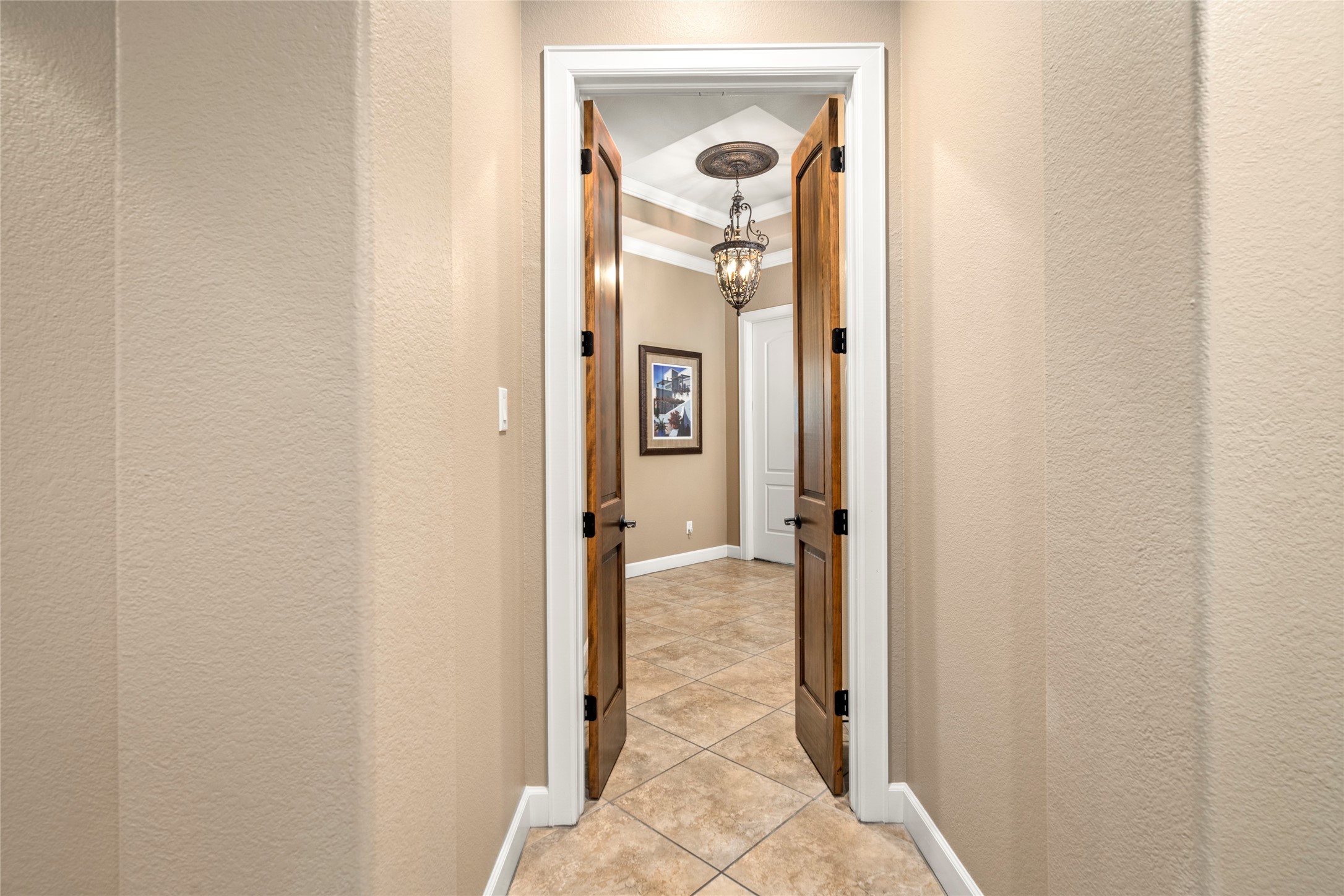 Custom wood doors open to the primary suite, a private wing of the home offering peaceful separation and refined entry.