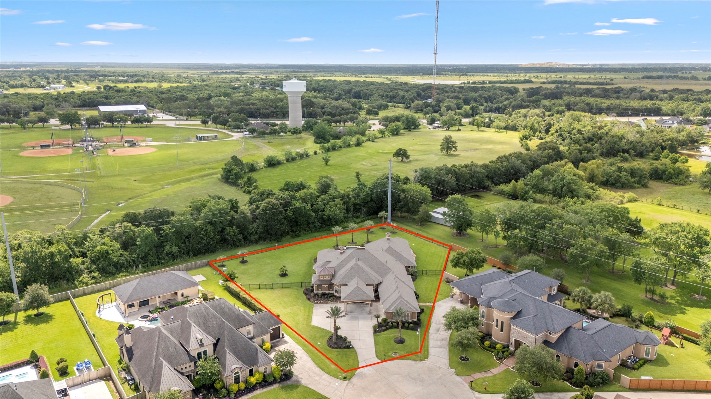 Aerial view showcasing this mediterranean style estate with just over one acre of sweeping grounds.