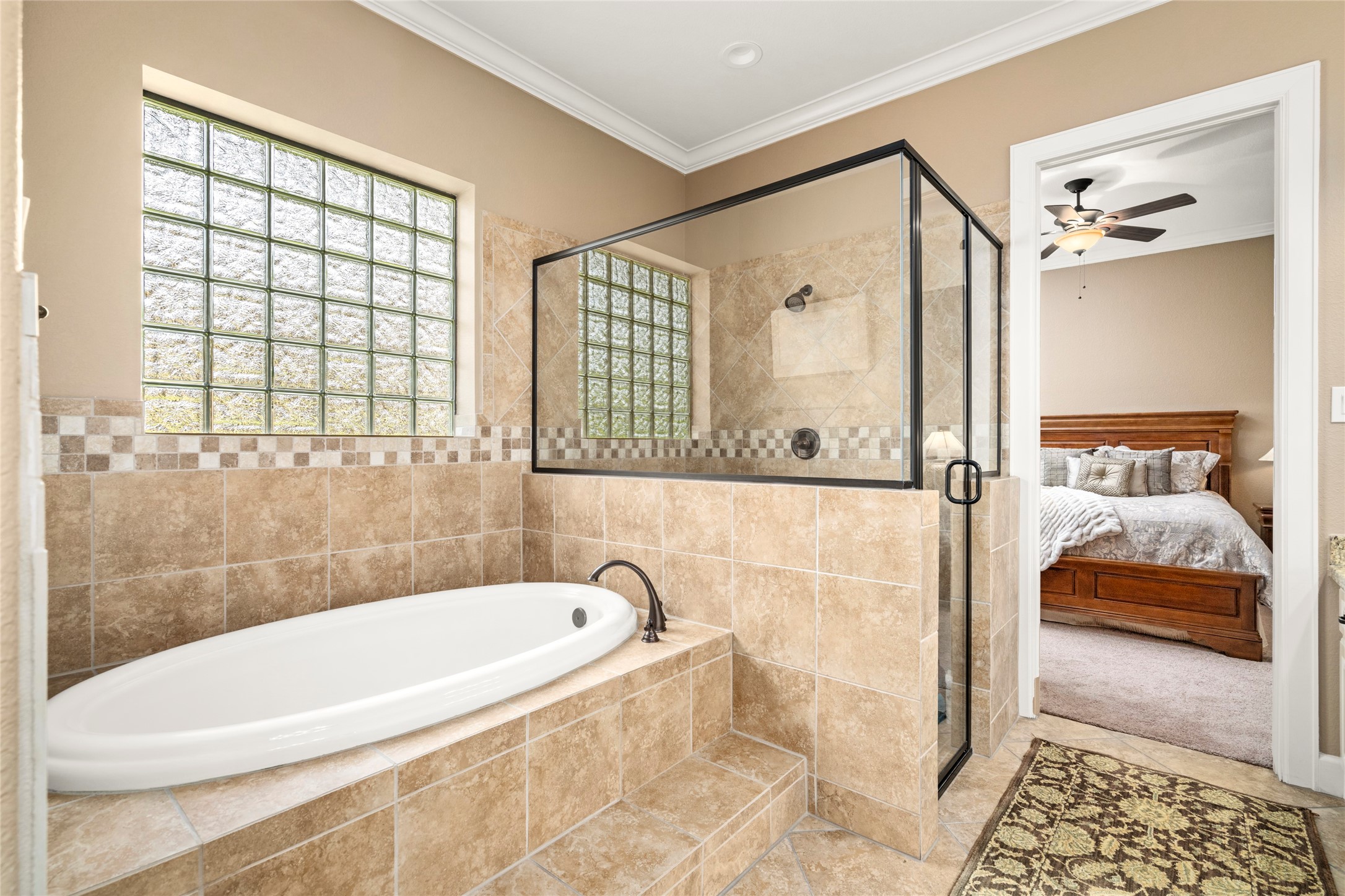 Shared bathroom between the two secondary bedrooms with a walk-in shower and an elevated soaking tub, feels like a mini primary suite for both rooms.