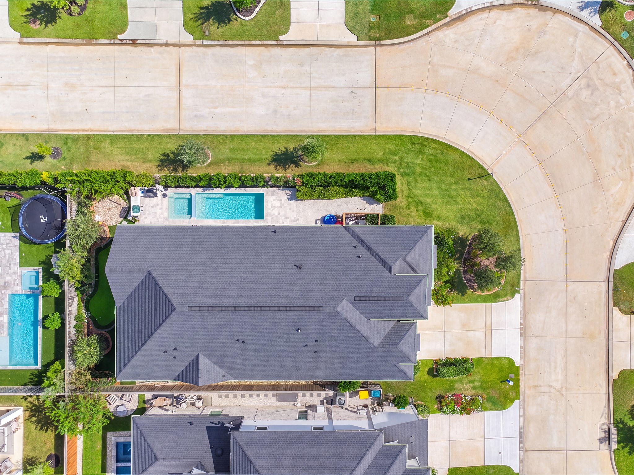 Bird's-eye view of the lot layout - single-story rooflines, the pool along the side yard, the covered patio and a fenced backyard with plenty of room to spread out.