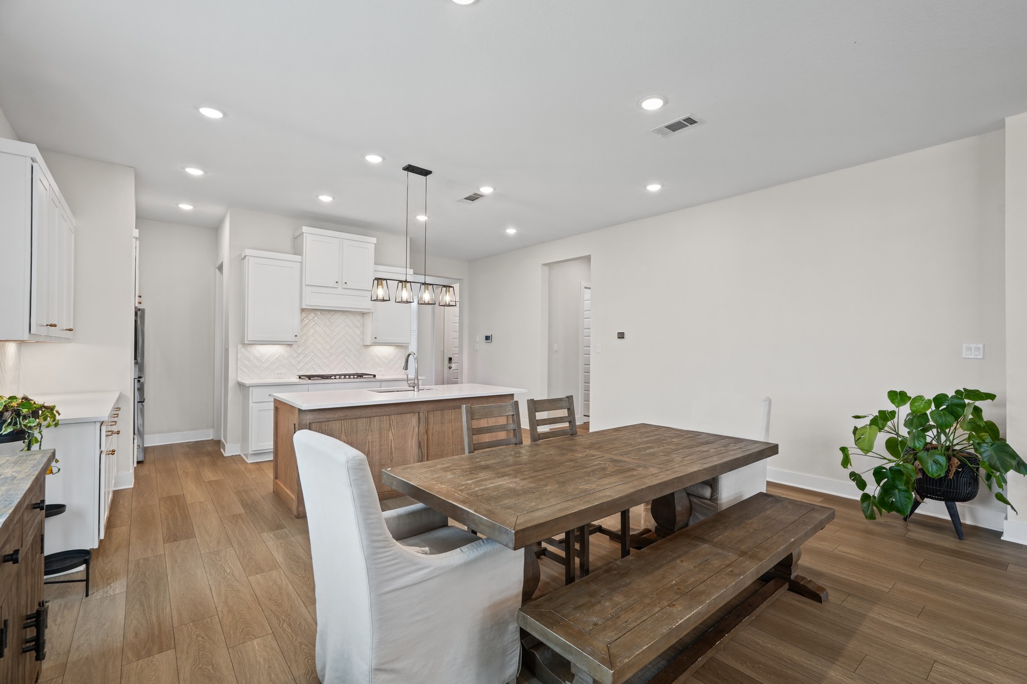 Looking from the dining area toward the kitchen and hall, the open sightlines make the single-story layout feel even larger and keep everyone connected across the main living space.