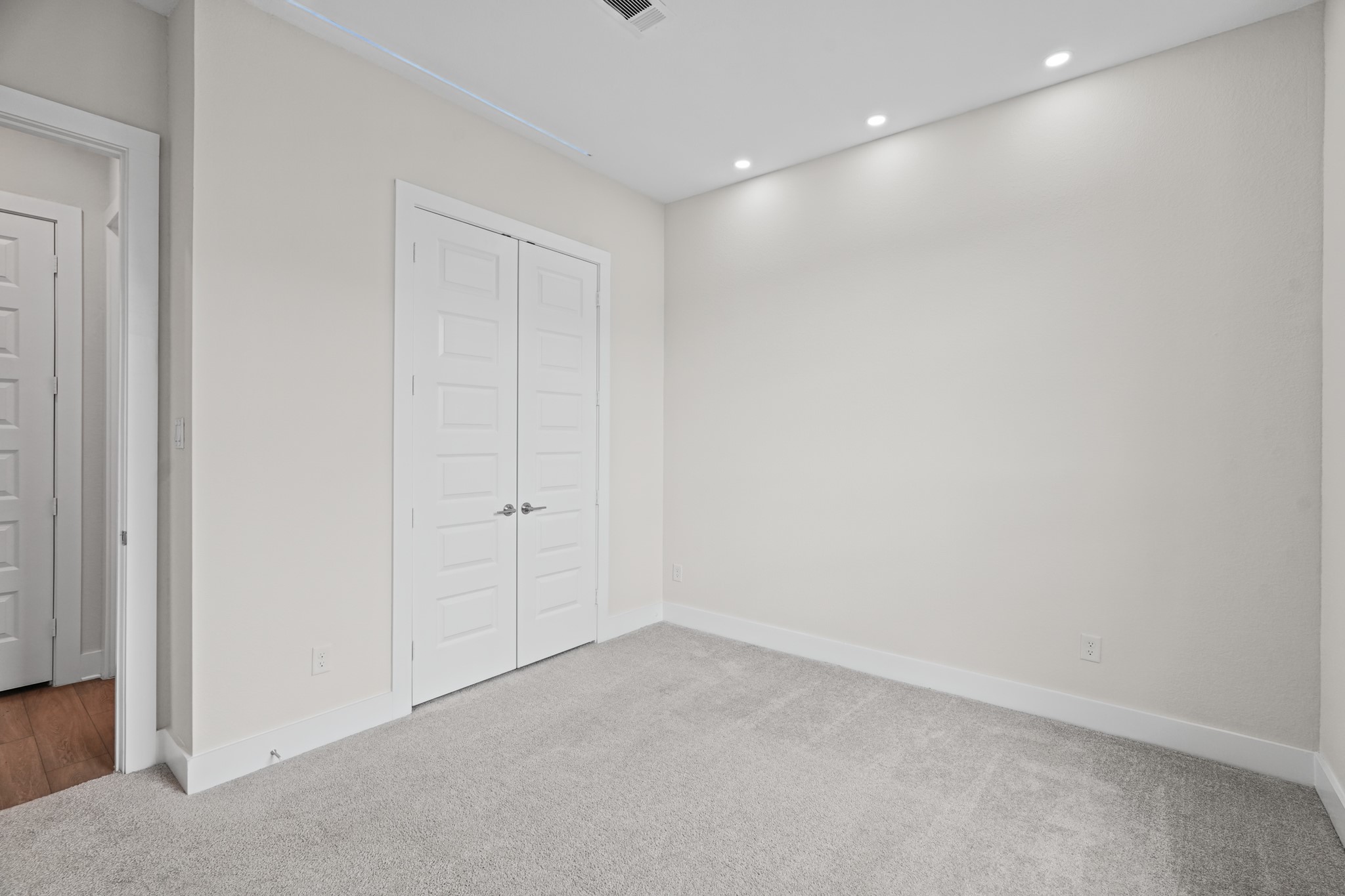 An additional bedroom offering closet storage, soft carpet underfoot and a quiet position down the hall from the home's main living, dining and entertaining areas.