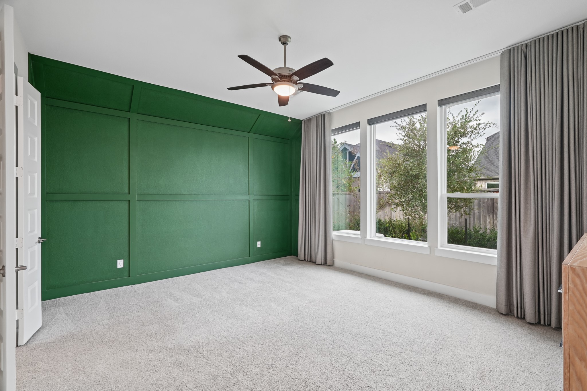 The primary bedroom measures approximately 13'8" x 16'9", with comfortable room for a king bed and a seating area, plus windows along the rear wall for soft natural light.