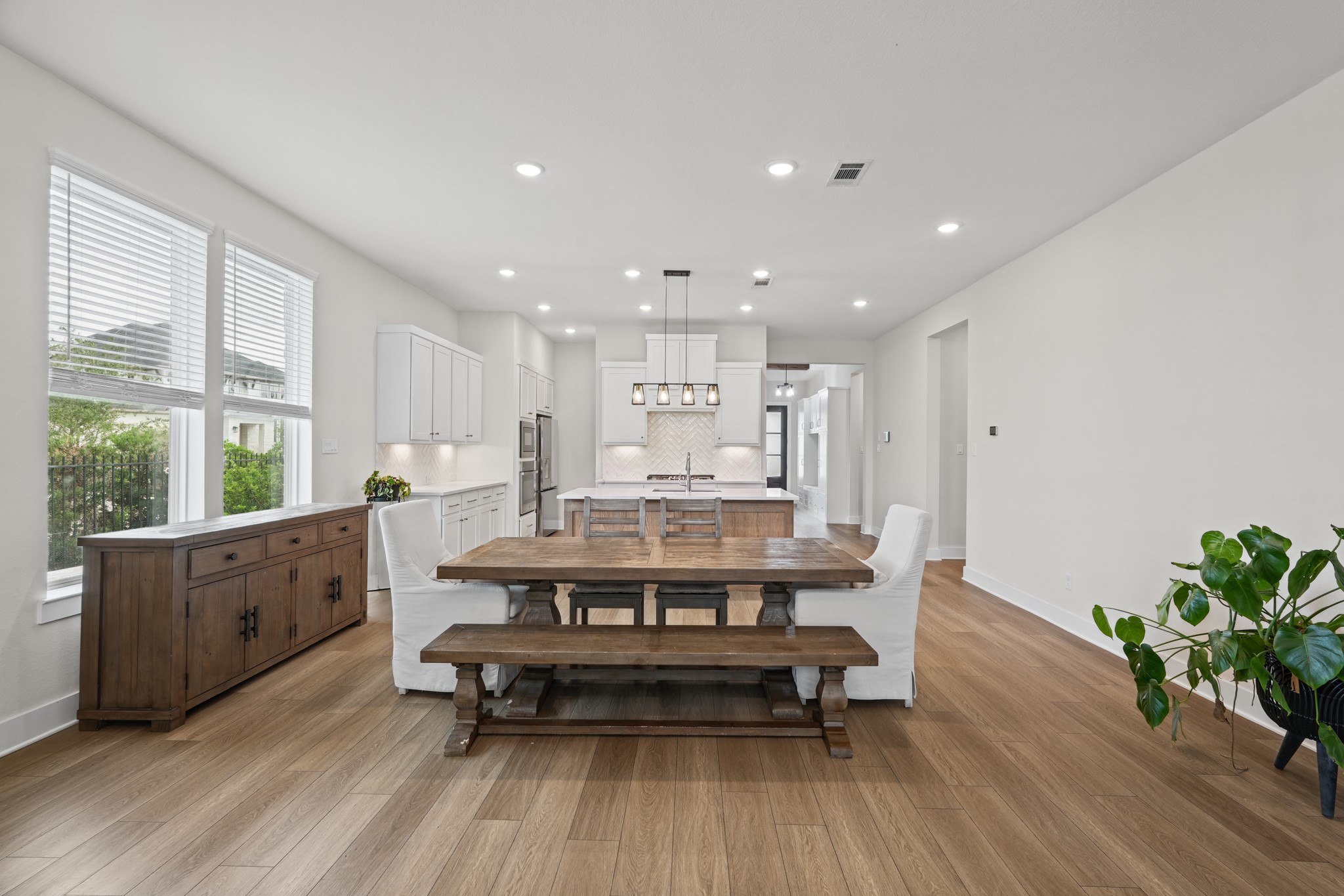 Natural light pours into the dining space through tall windows, with wide-plank floors and a neutral palette ready to suit any furniture style or color scheme you bring.