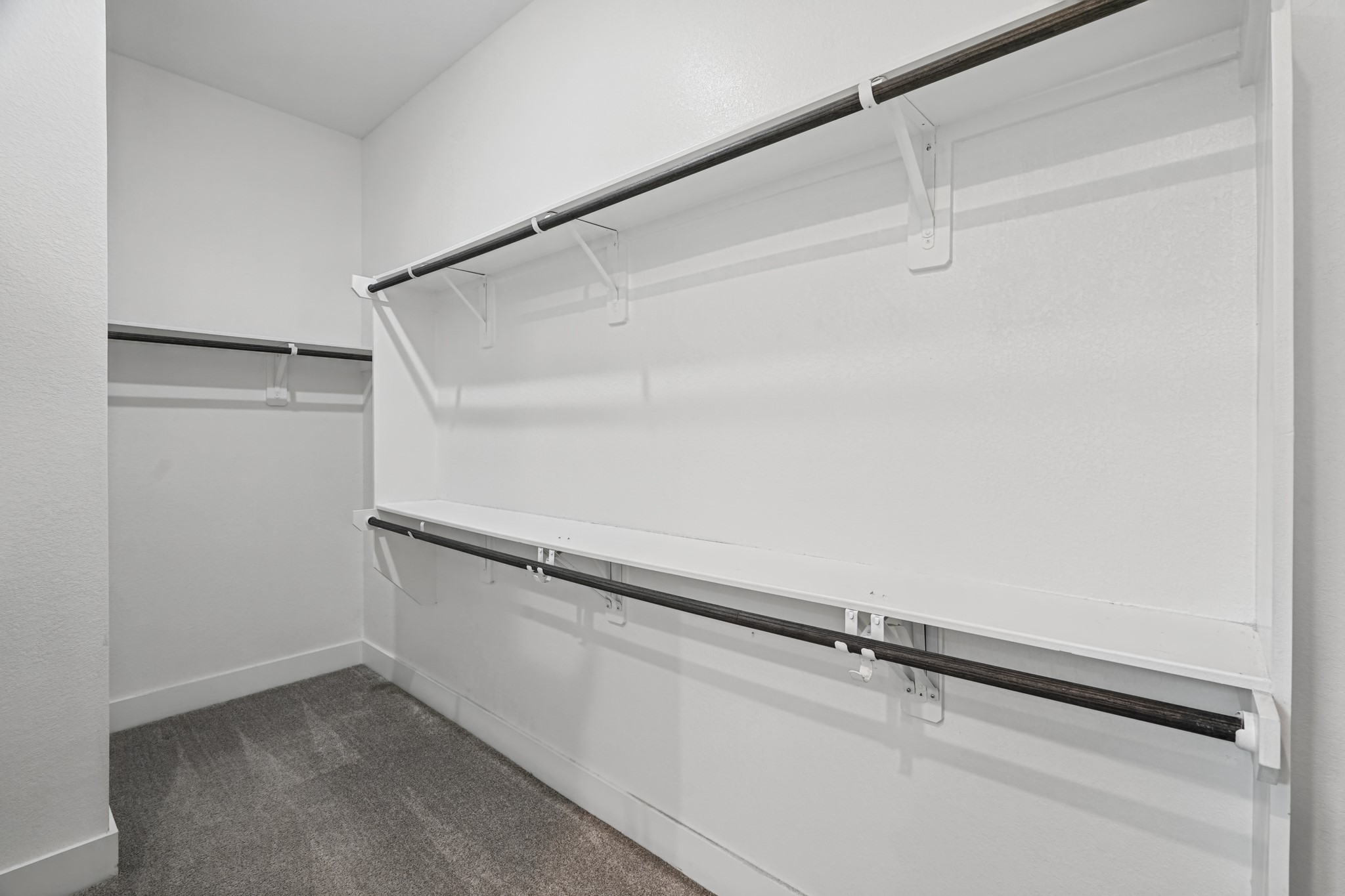 The oversized primary walk-in closet is fully fitted with hanging rods and shelving on multiple walls - generous, well-planned storage that keeps the suite organized and tidy.