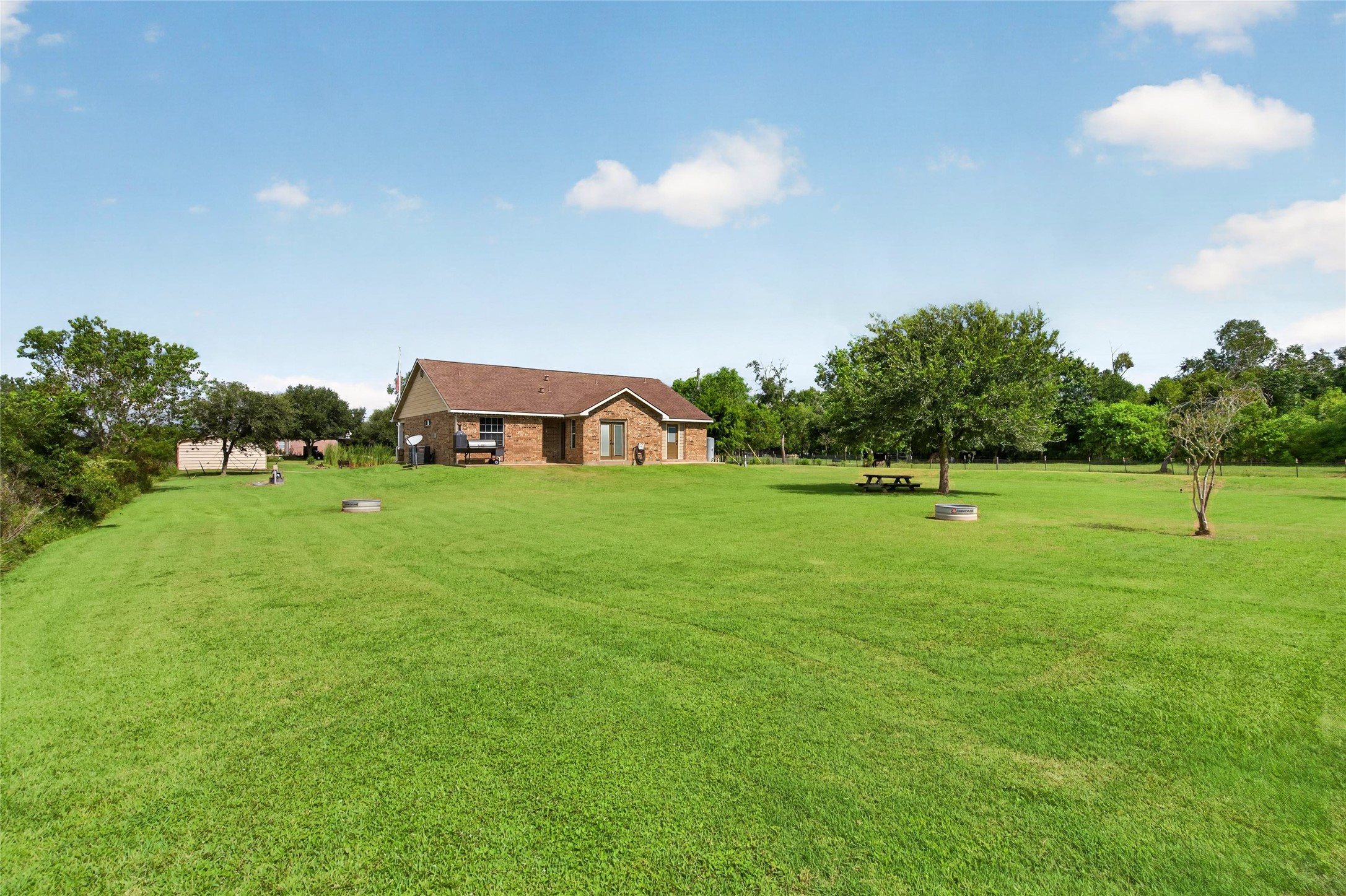Expansive backyard with wide-open green space, mature trees, and plenty of room to enjoy the outdoors.