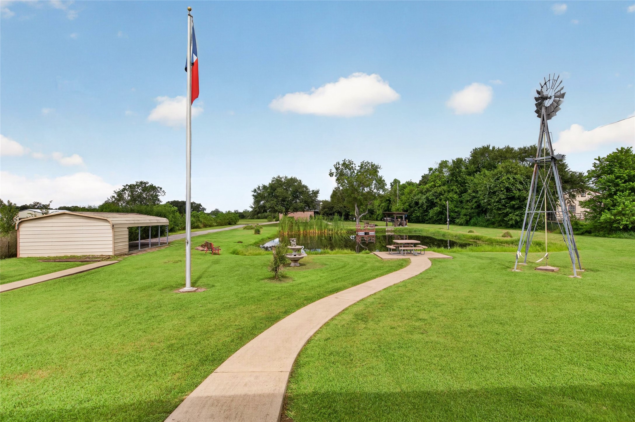 Spacious covered parking area with a gravel drive and attached storage building.