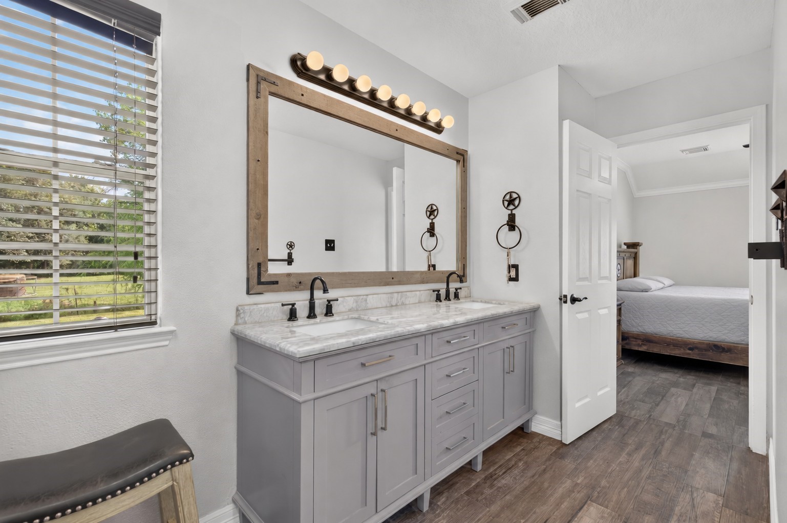 Completely updated en-suite bath featuring dual sinks, vanity, stylish fixtures, and a bright, spacious layout.