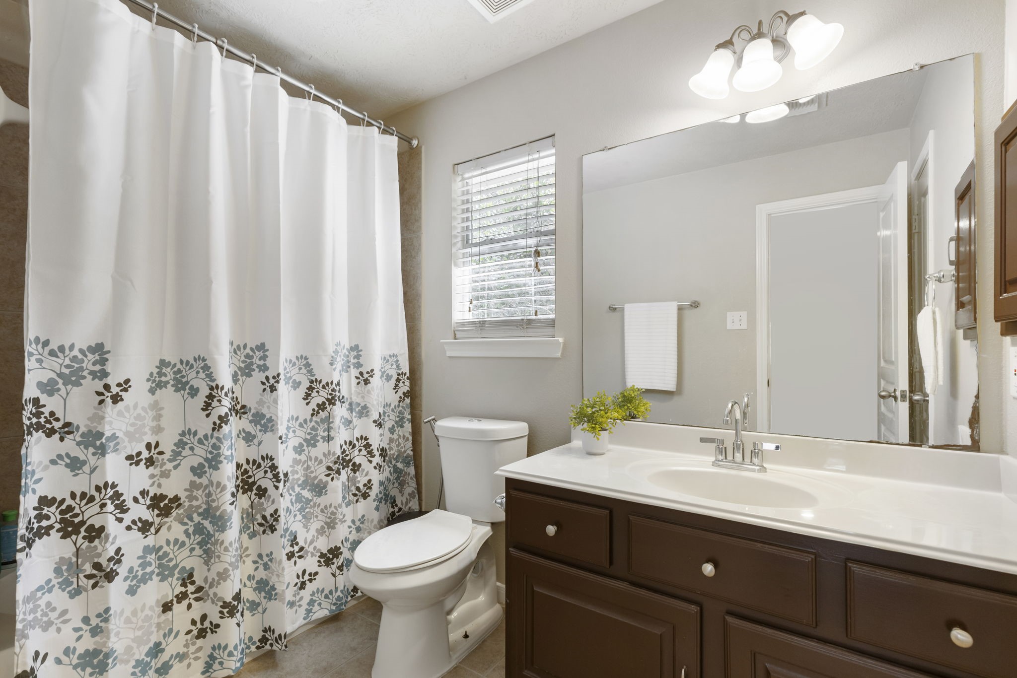 The upstairs secondary bathroom features an extended vanity with ample counter space, great storage, and a bright, functional layout designed for everyday convenience.