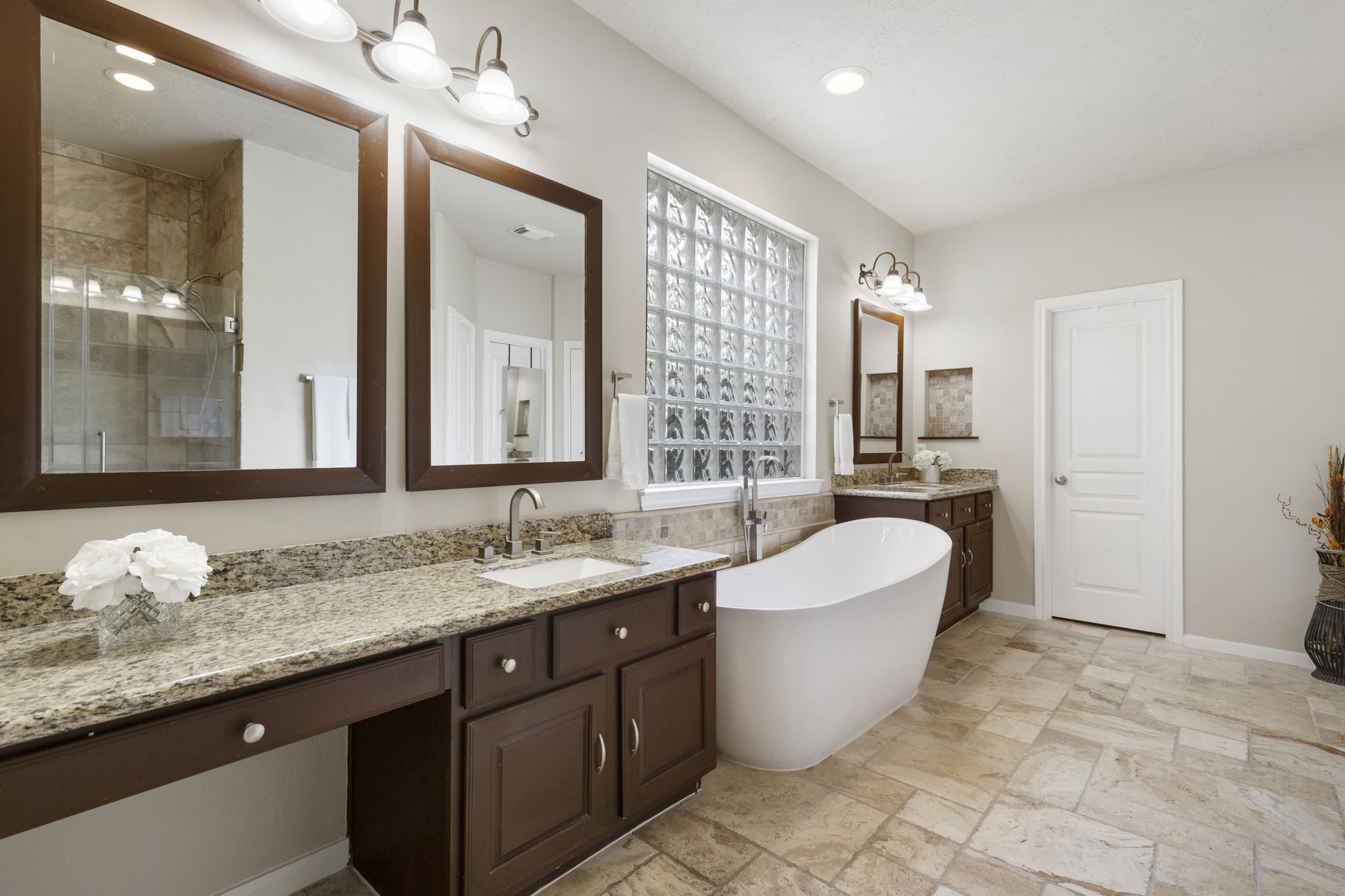 Beautiful dual vanities with granite countertops, generous counter space, and separate sinks provide both style and functionality in the primary bath.