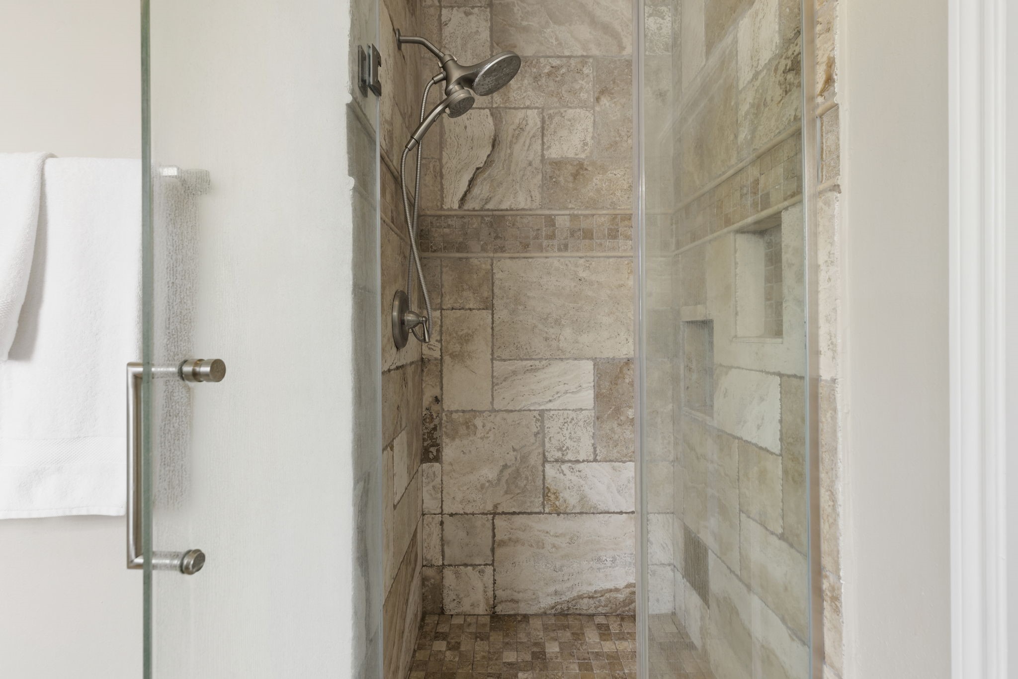 Updated walk-in shower featuring frameless glass, tile surround, and a clean, timeless design.