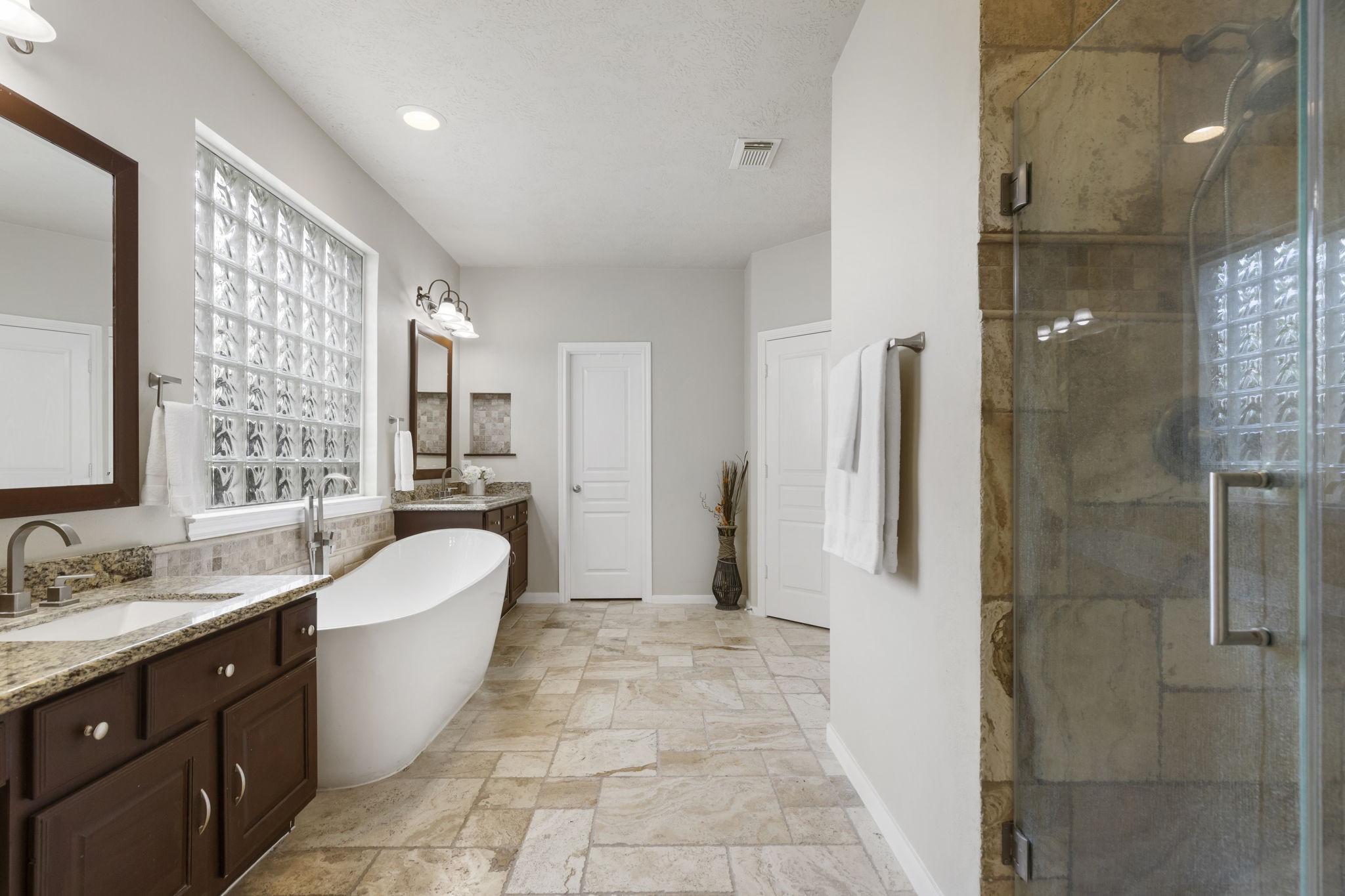 A serene primary bath retreat featuring a freestanding soaking tub, spacious layout, natural light, and elegant finishes designed for relaxation.