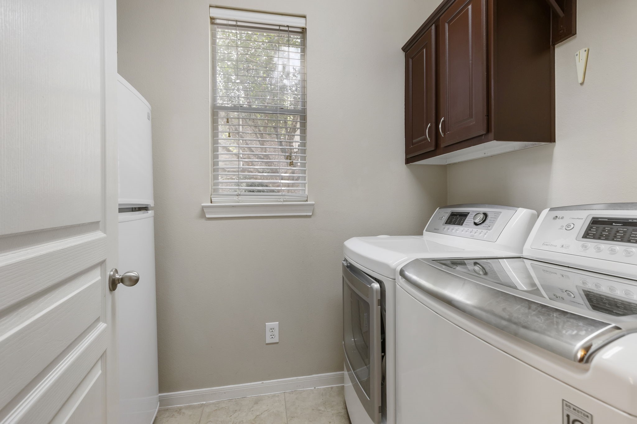 A in house laundry room with built-in cabinetry provides extra storage and convenience to help keep everyday tasks organized.