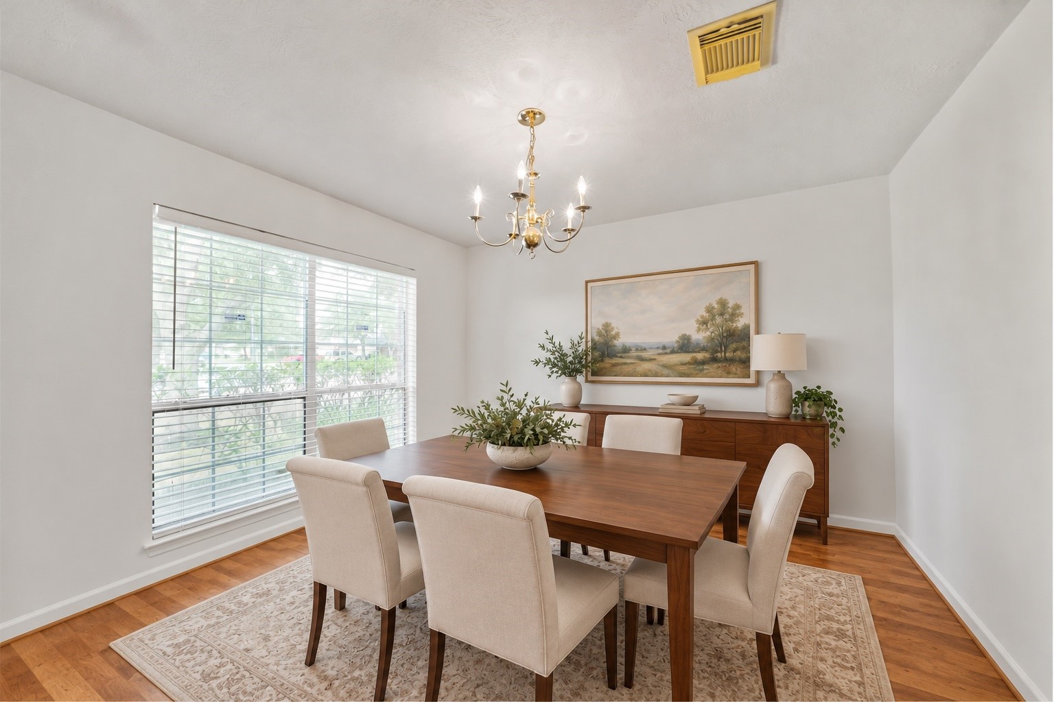 Virtually staged: Beneath the chandelier, the formal dining room is reimagined as an inviting place to gather, pairing warm wood flooring with a table for six, tailored seating, and a sunlit front window. Virtually staged: Beneath the chandelier, the formal dining room is reimagined as an inviting place to gather, pairing warm wood flooring with a table for six, tailored seating, and a sunlit front window.