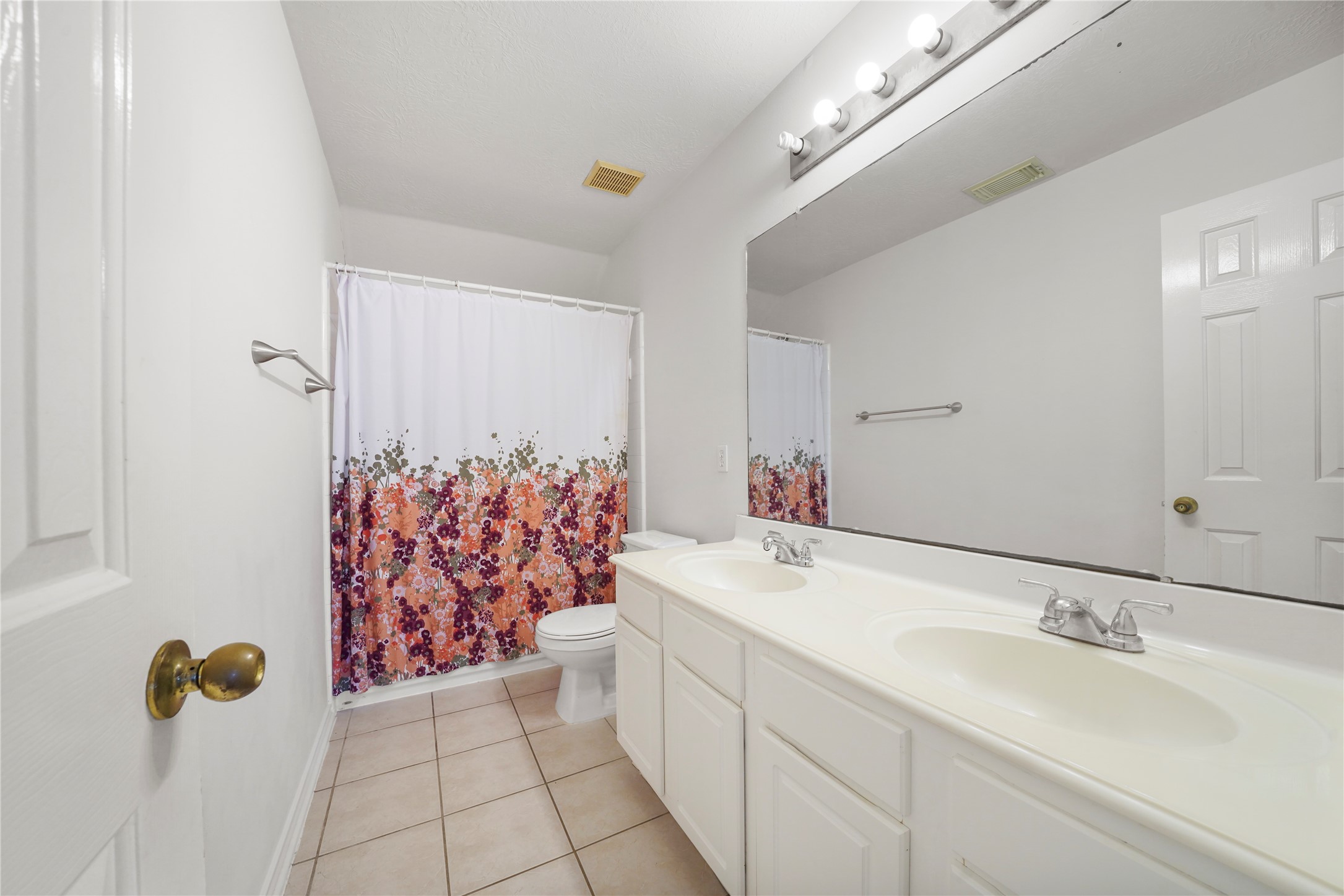 The shared upstairs bath pairs a double-sink vanity with a tub/shower combination to help the day start and end with ease.