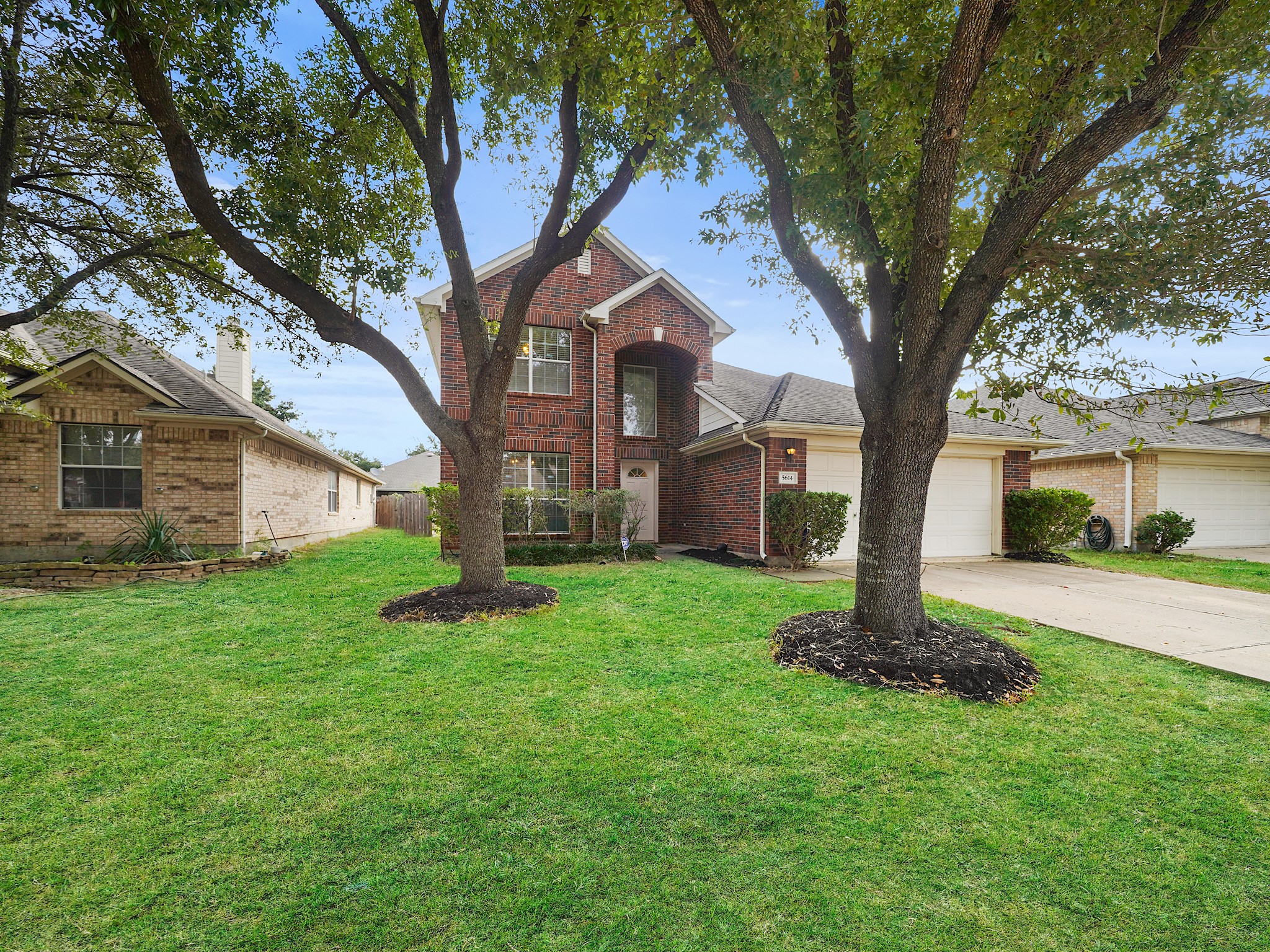 Set beneath mature shade trees, the brick faade and wide driveway create a warm first impression, with the two-car garage tucked neatly beside the covered entry. Set beneath mature shade trees, the brick faade and wide driveway create a warm first impression, with the two-car garage tucked neatly beside the covered entry.