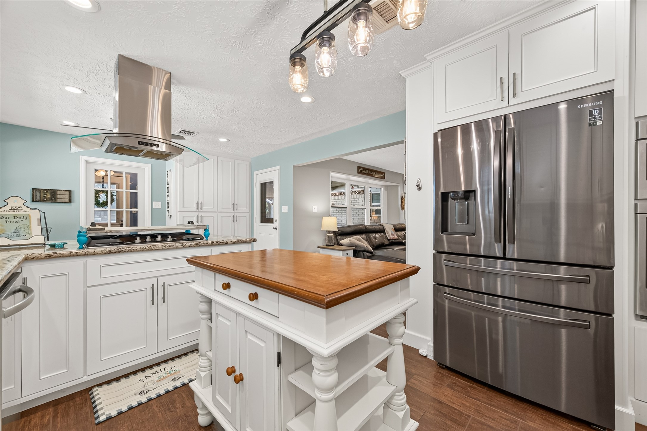 ANOTHER VIEW OF THE KITCHEN, THE GLASS DOOR LEADS TO THE LAUNDRY ROOM, THE DOOR IN THE MIDDLE LEADS TO THE COVER BACK PATIO WITH A CUSTOM BUILT SCREEN DOOR AND THE LIVING ROOM TO THE RIGHT;