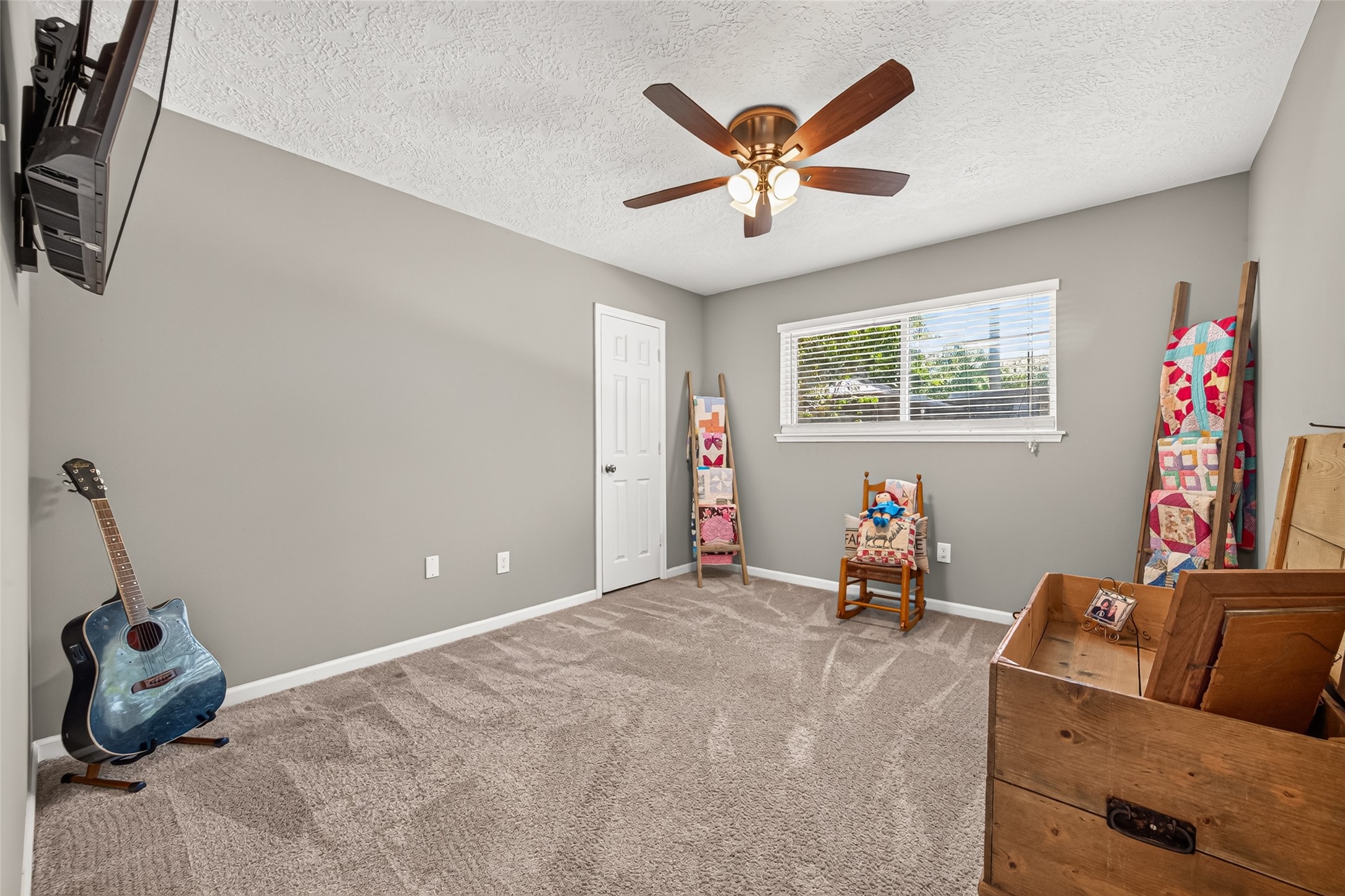 THIS SECONDARY BEDROOM HAS A WALK IN CLOSET AND MOUNTED TV THAT WILL REMAIN WITH HOME. THE LARGE WINDOW OFFERS LOTS OF NATURAL LIGHT.
