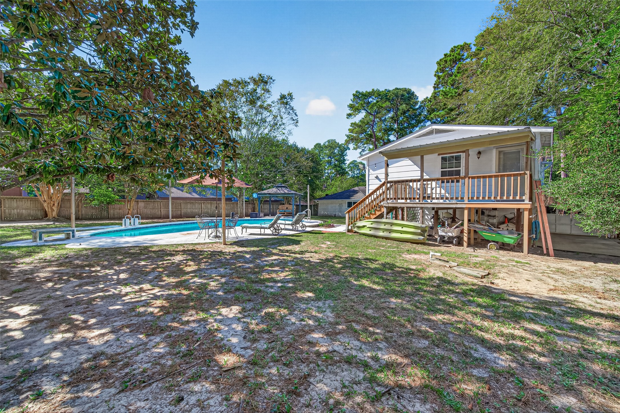 ANOTHER VIEW OF THE BACK YARD AND POOL HOUSE ON THE LEFT. AND LOTS OF SPACE TO STORE ALL YOUR OUTDOOR ITEMS UNDER THE POOL HOUSE.