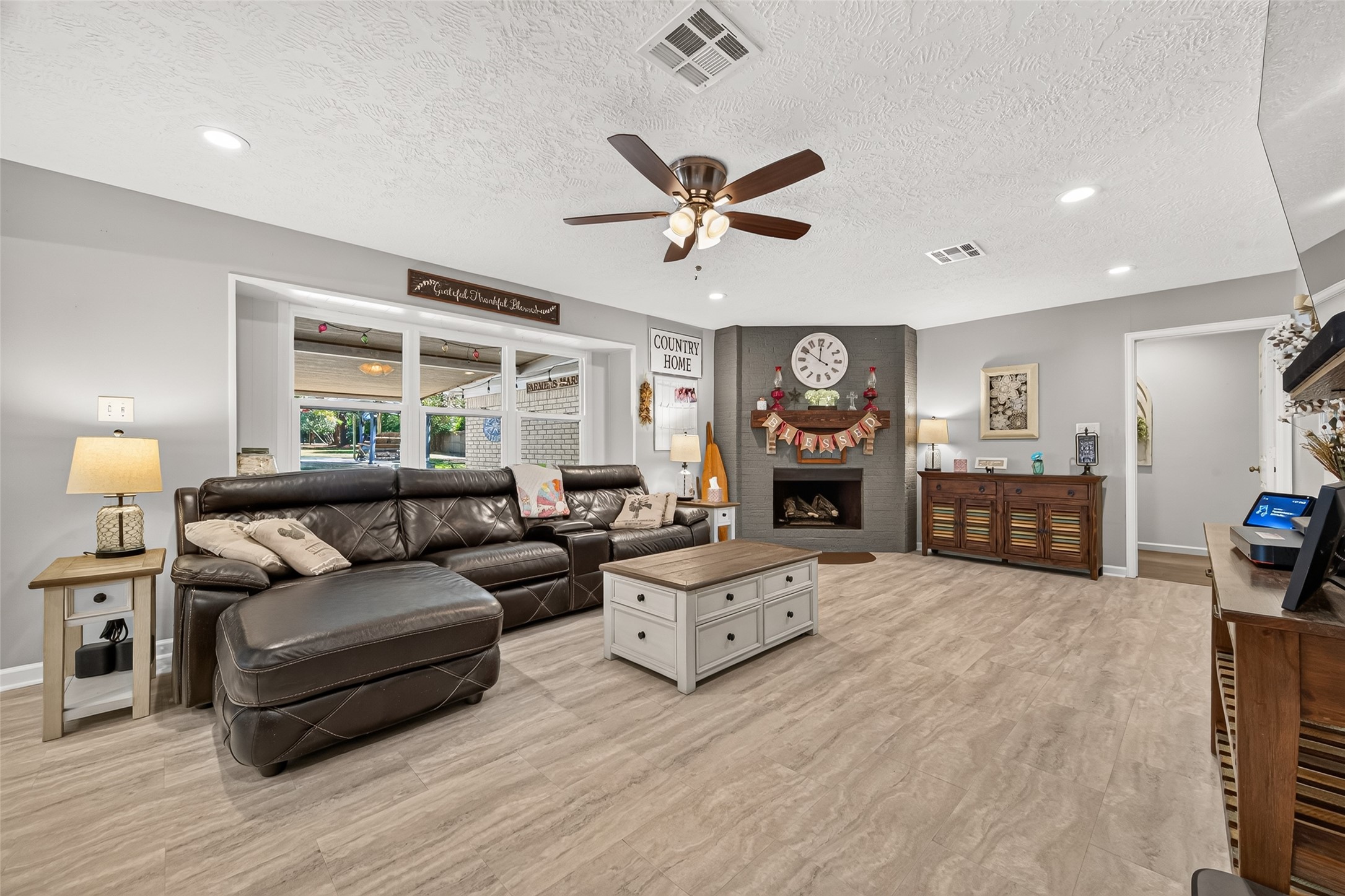 VERY SPACIOUS LIVING ROOM WITH LOTS OF NATURAL LIGHT, WOOD OR GAS BURNING FIREPLACE; VINYL FLOOR; THE DOOR TO YOUR FAR RIGHT LEADS TO ALL THE BEDROOMS AND GUEST BATHROOM.