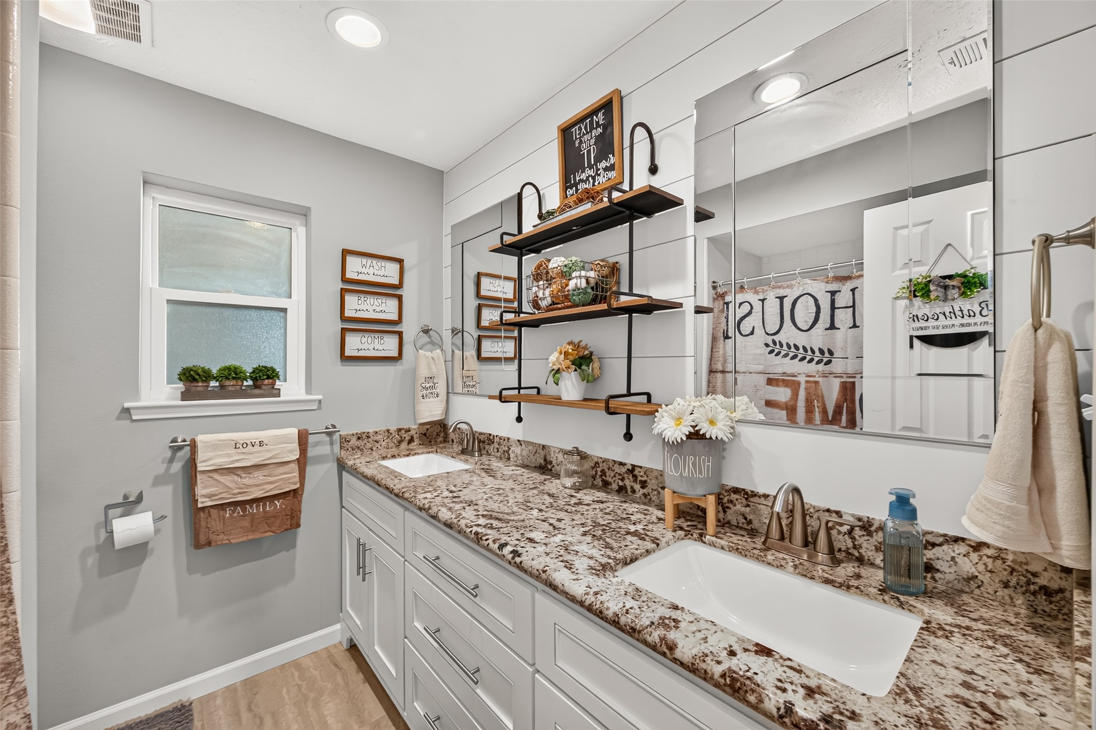 THE GUEST BATHROOM OFFERS A BEAUTIFUL GRANITE COUNTERTOP, DOUBLE SINKS, A TUB/SHOWER COMBO, CUSTOM SHELVES AND AN ABUNDANCE OF STORAGE.