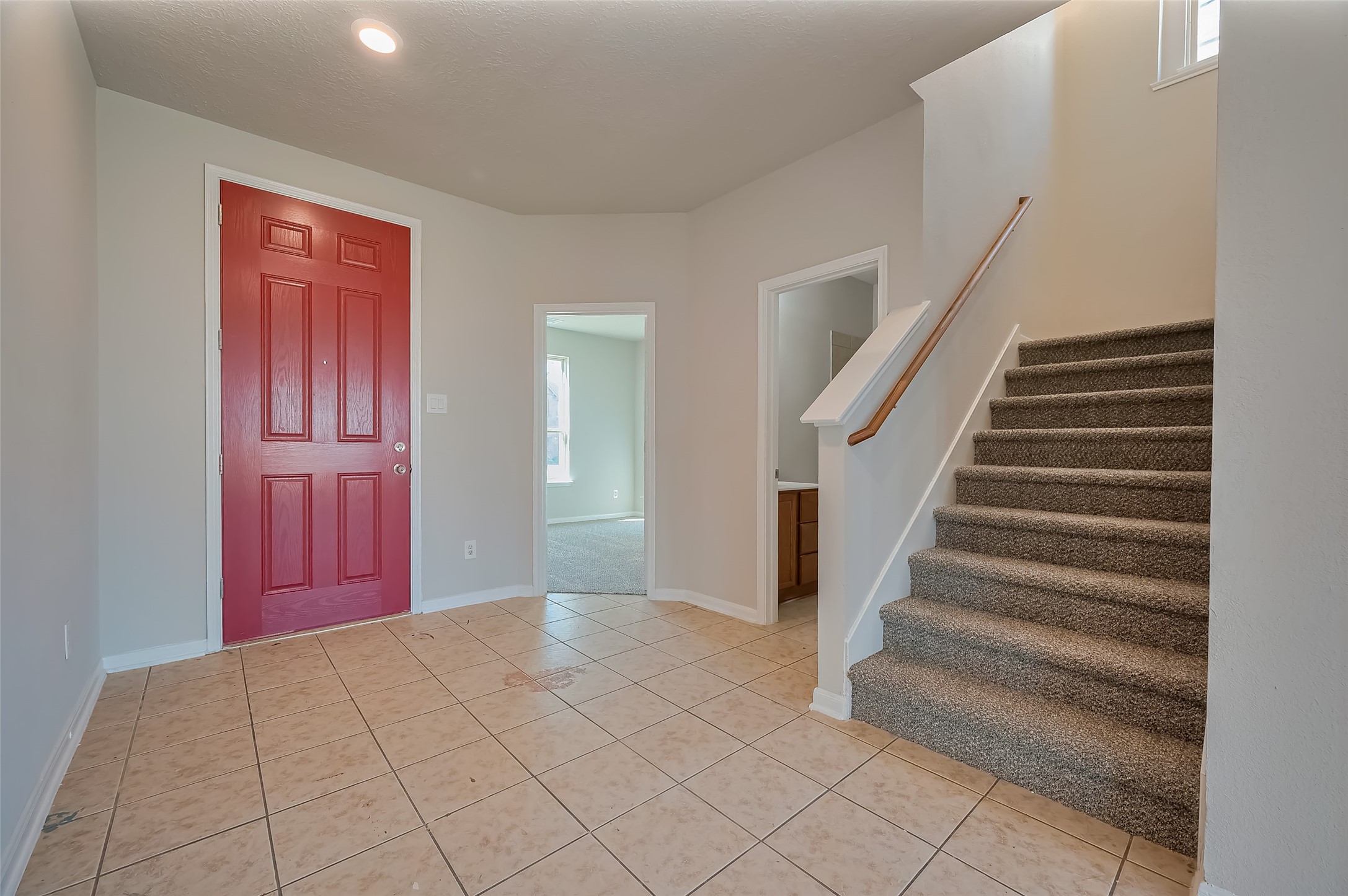 Entryway featuring bold red door.