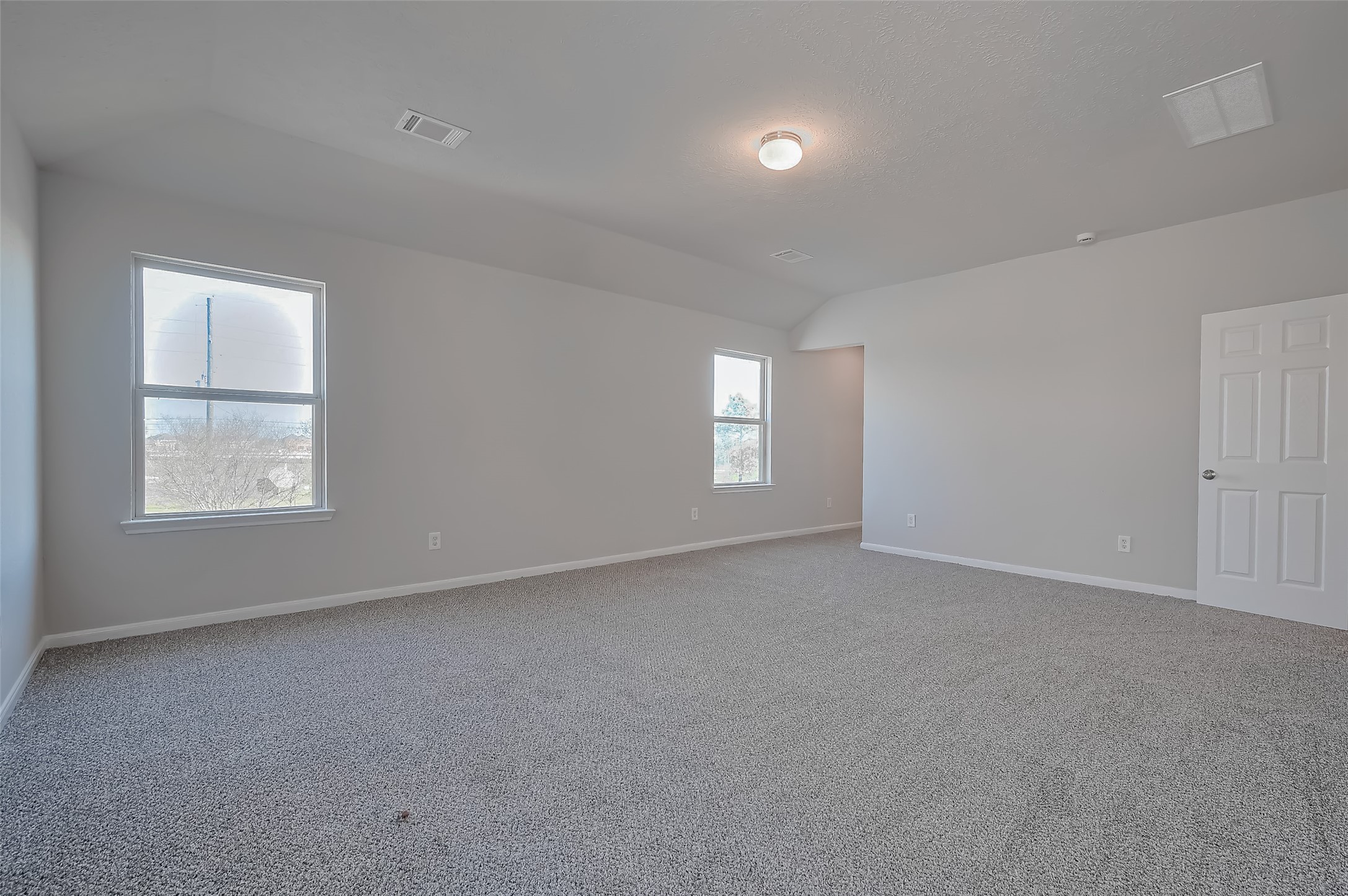 Bedroom boasts neutral walls and plush carpeting.