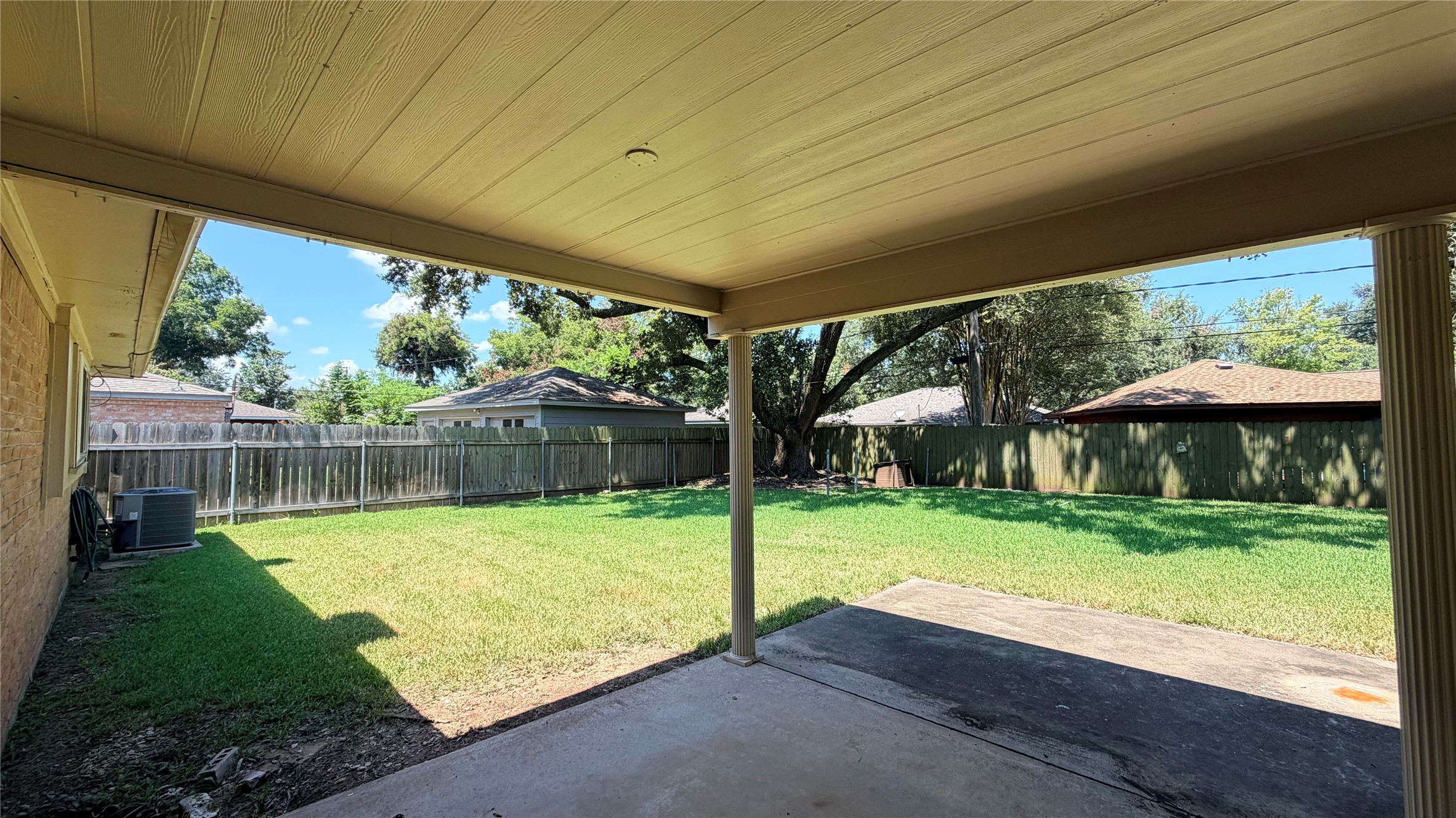 Step from the bright, open living space onto a patio that offers serene views of the lush backyard, perfect for relaxation and outdoor gatherings.