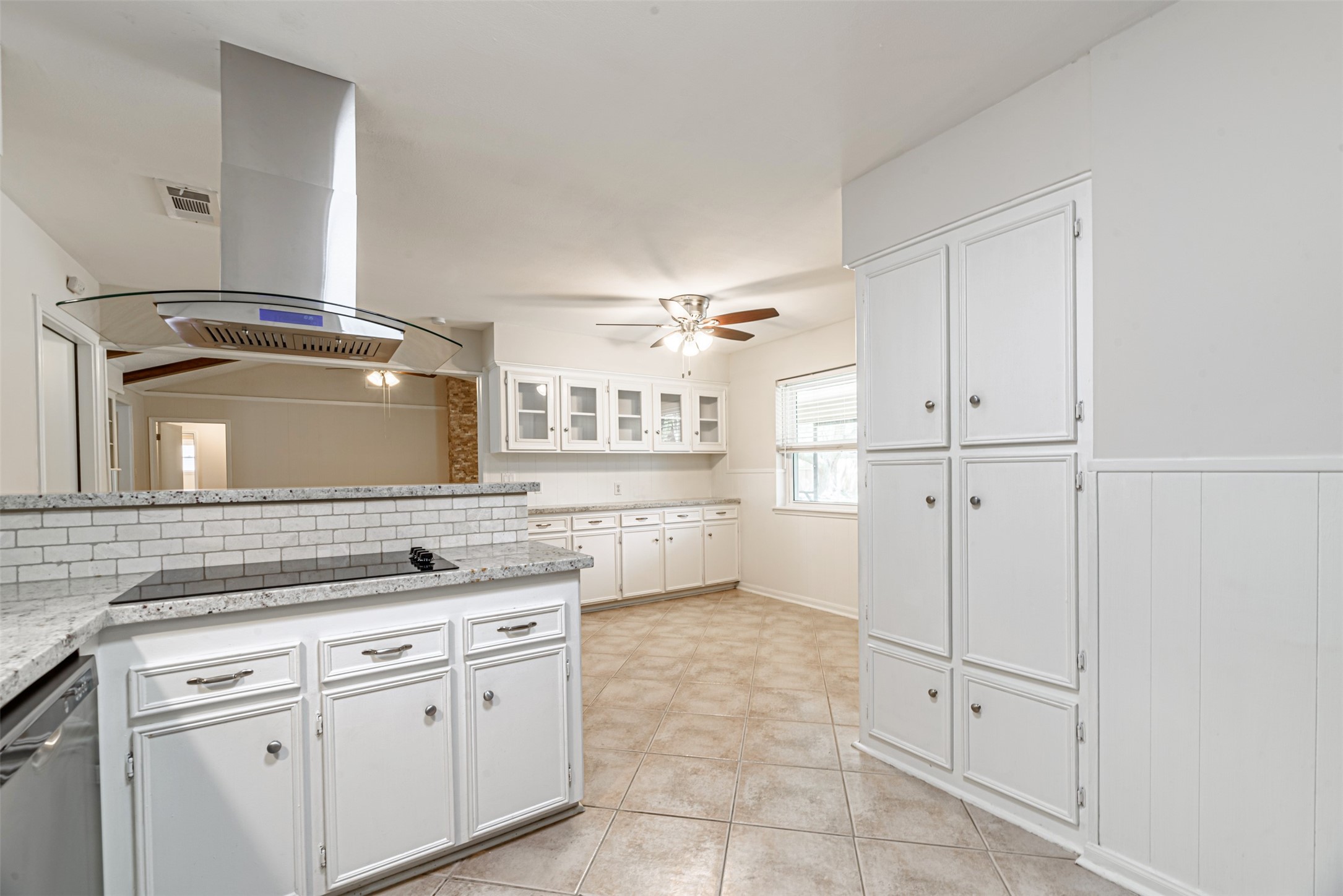 Discover modern culinary elegance with an electric cooktop and sleek stainless steel appliances, perfectly complementing the bright and spacious kitchen.