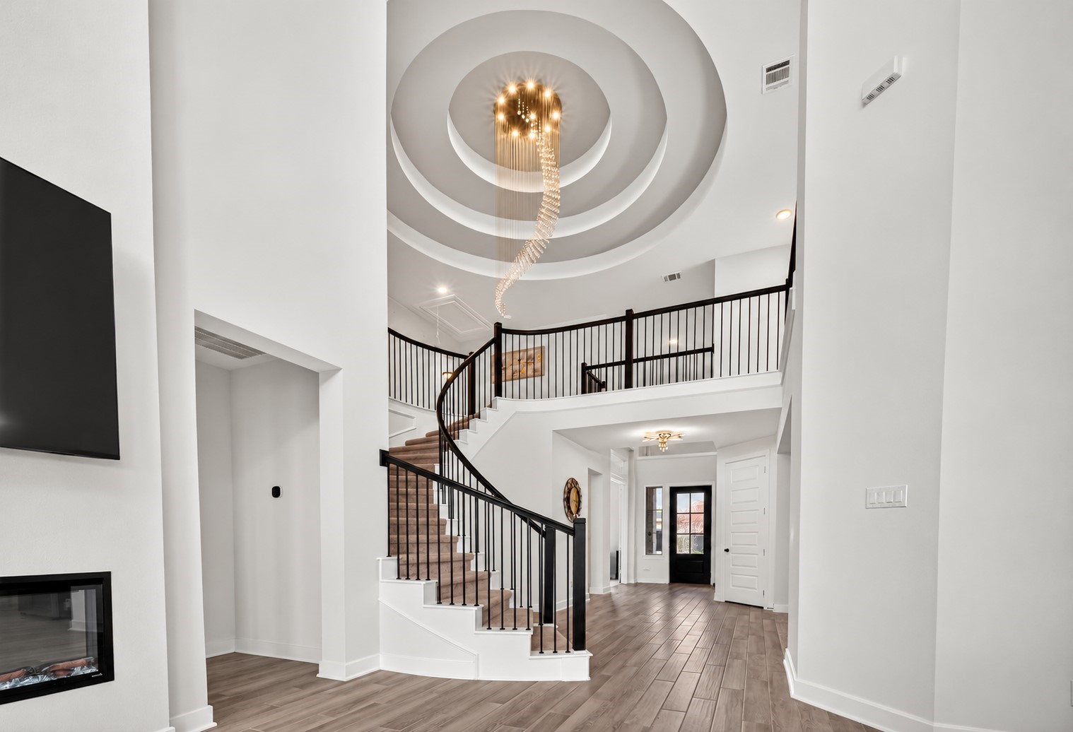 A breathtaking curved staircase makes a grand architectural statement, complemented by an exquisite chandelier that adds elegance, drama, and timeless luxury to the homes interior