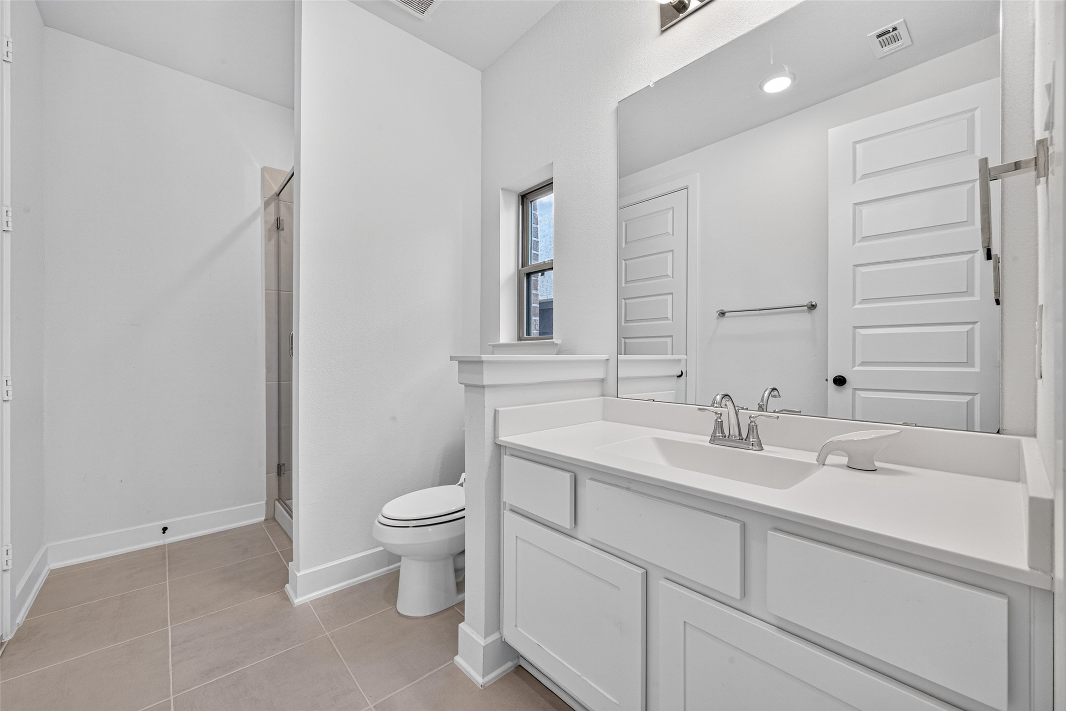 The guest bedrooms private en-suite features a spacious vanity with ample counter space, blending everyday functionality with a polished, elegant design for added comfort and convenience