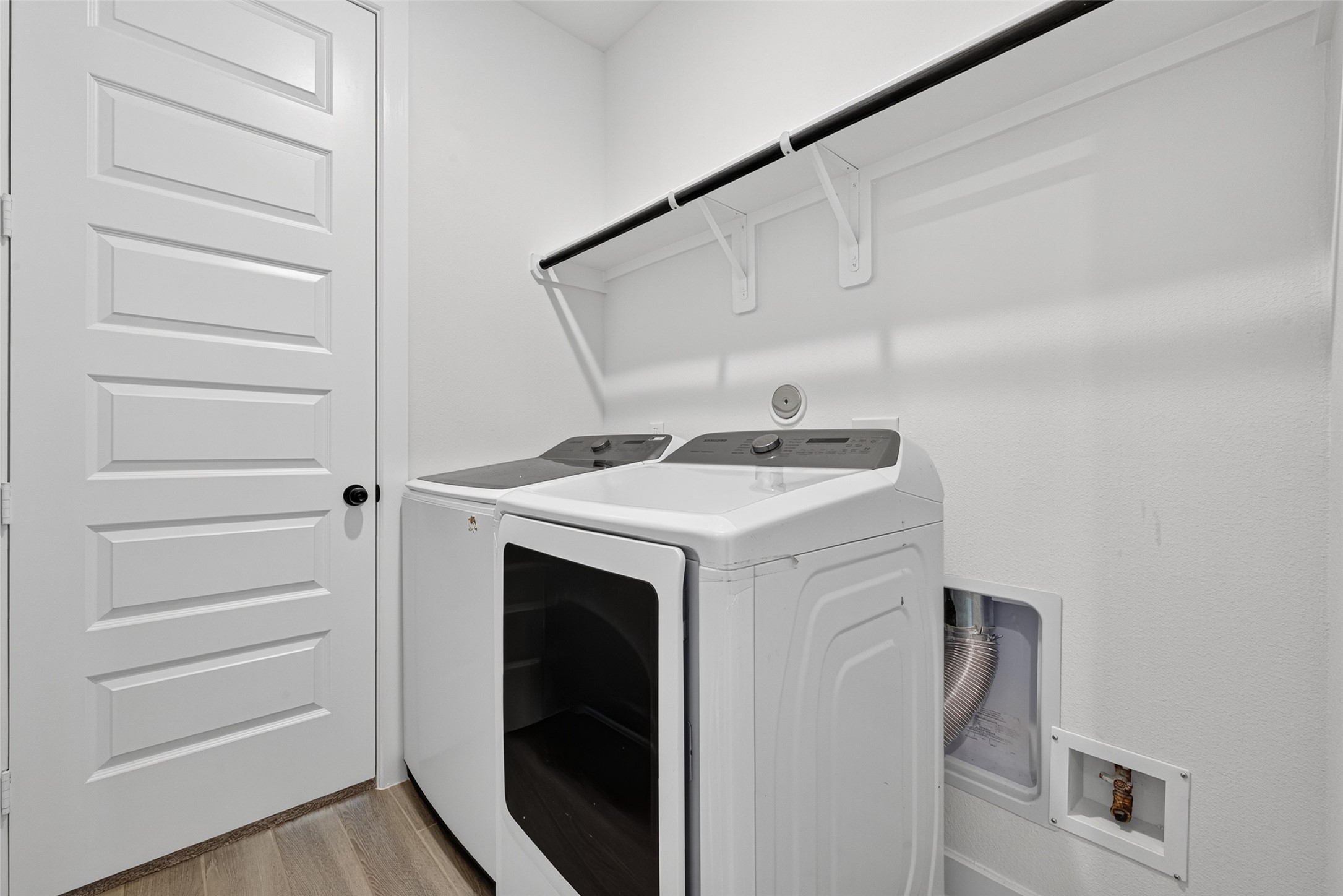 A well-appointed laundry room featuring a convenient built-in shelf for added storage and organization, combining everyday functionality with a clean, polished design