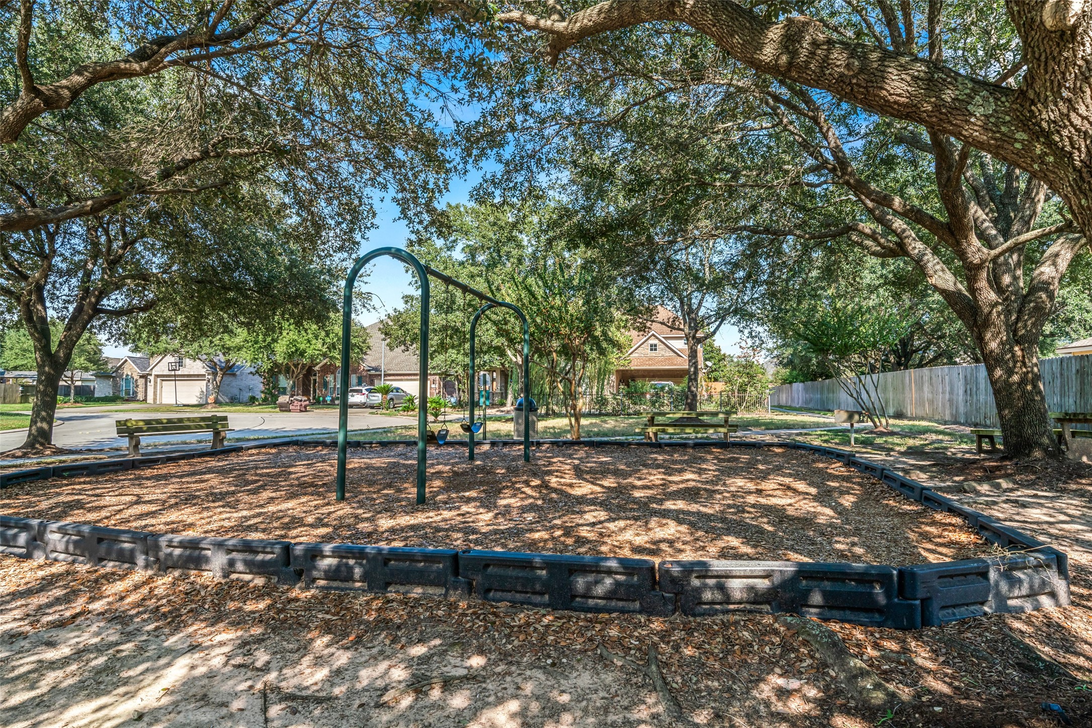 A smaller playground with a swings on the walking path entrance to the "Big Lake" walking trail.